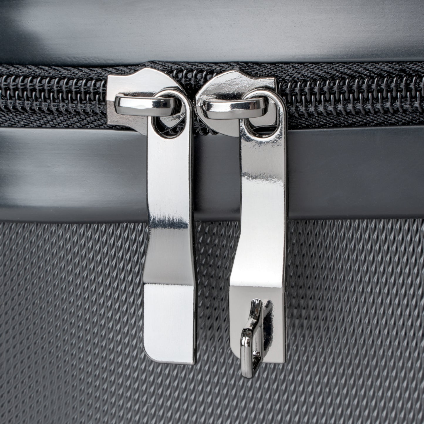 Close-up of a silver zipper on a textured gray surface