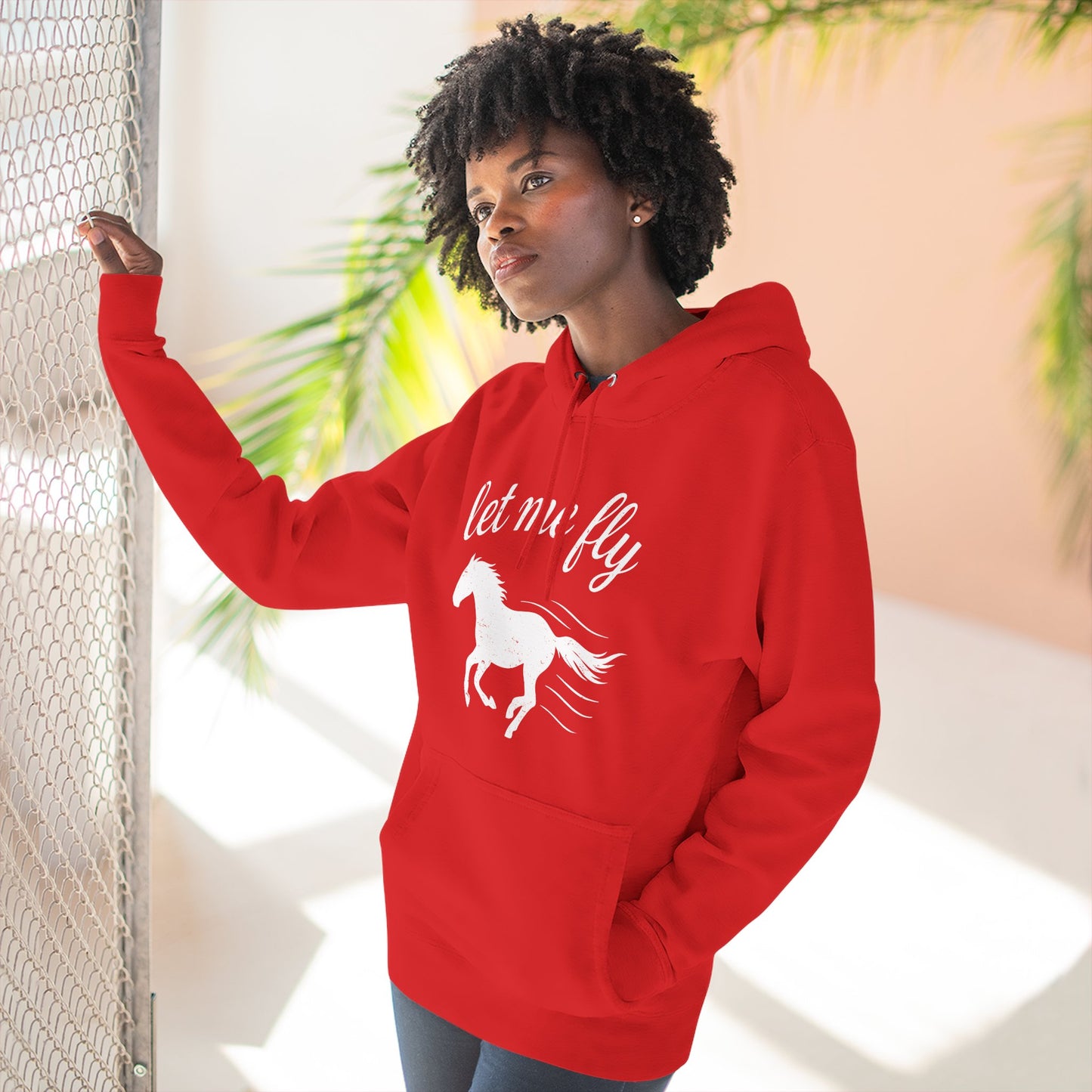 Person wearing a red hoodie with a horse graphic and text, standing indoors.