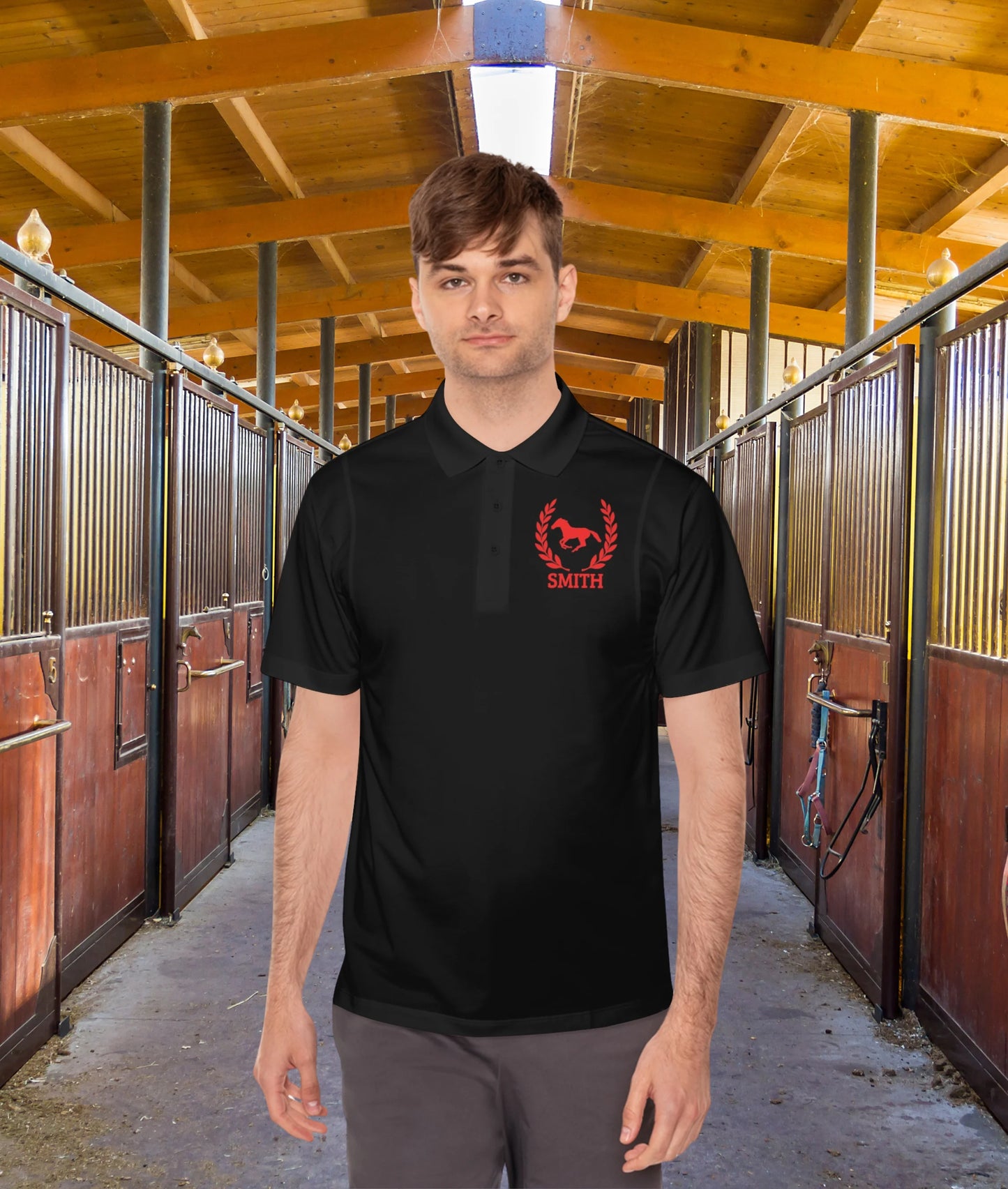 black polo shirt red horse Man wearing a black polo shirt with a red logo in a stable setting