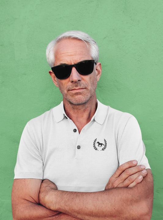 Man wearing sunglasses and a white polo shirt with a logo against a green background