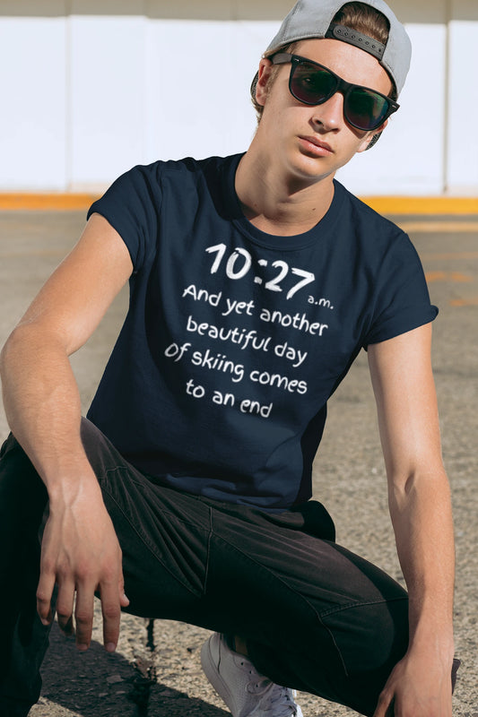 Person wearing a navy blue t-shirt with text, sitting outdoors.