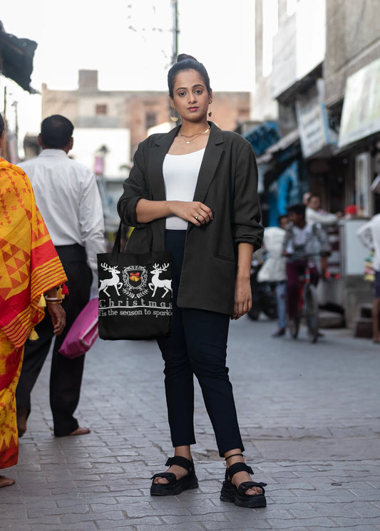 Woman walking on a street holding a black bag with white designs