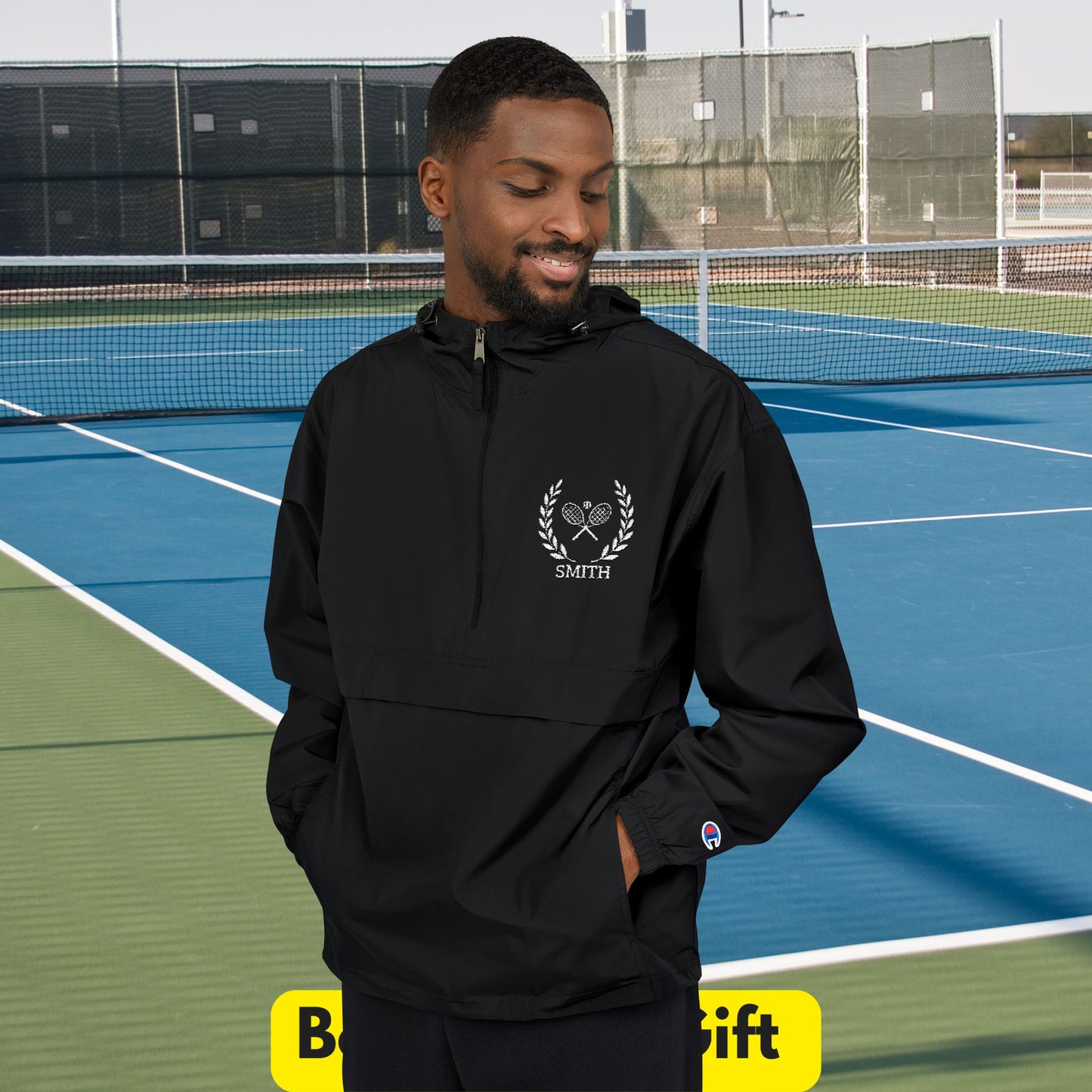 Tennis jacket Man wearing a black hoodie with a logo on a tennis court