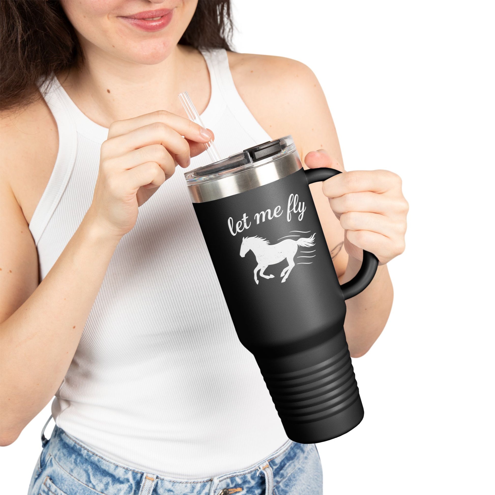 Person holding a black travel mug with 'let me fly' and horse design on a white background