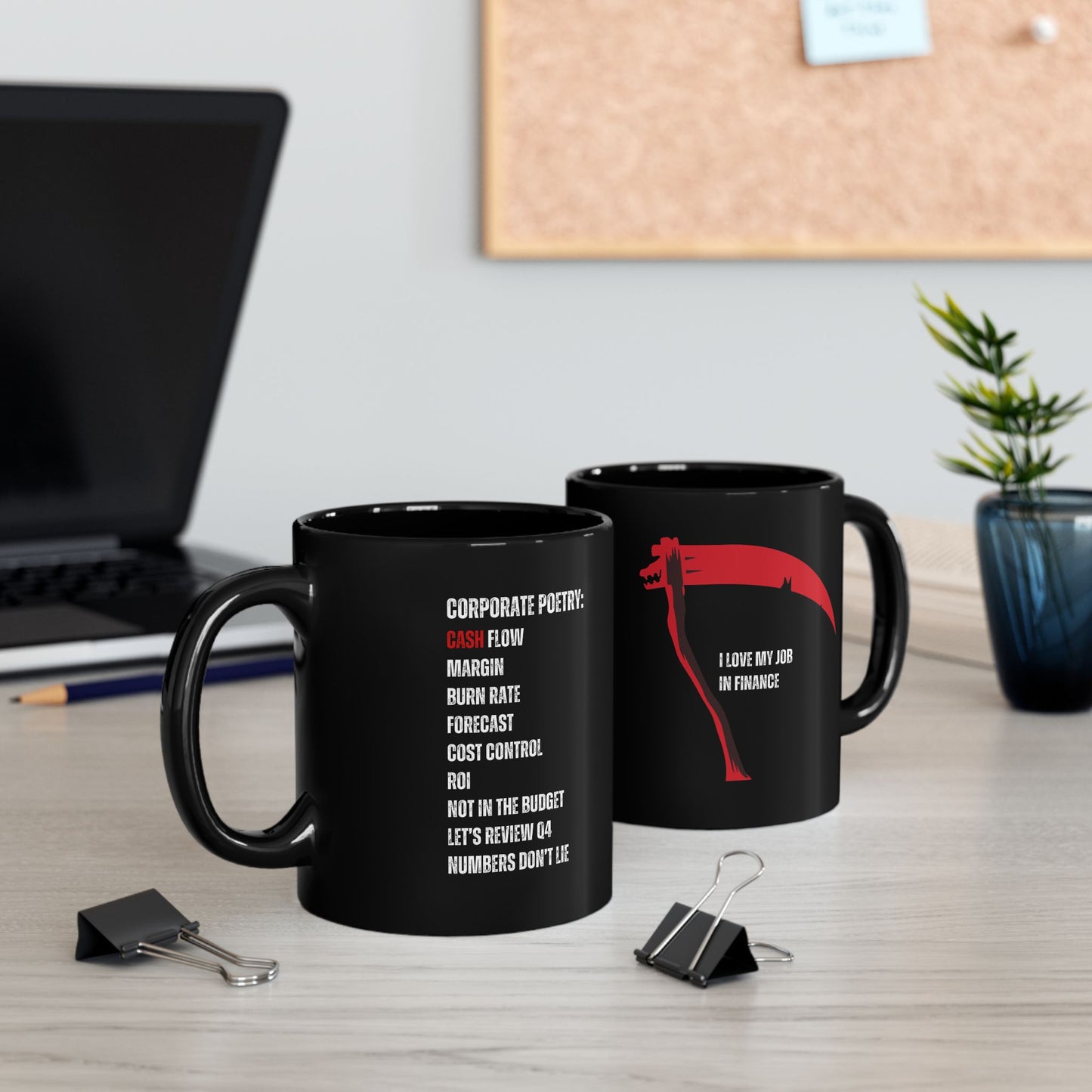 Two black mugs with humorous text designs on a desk with office items.