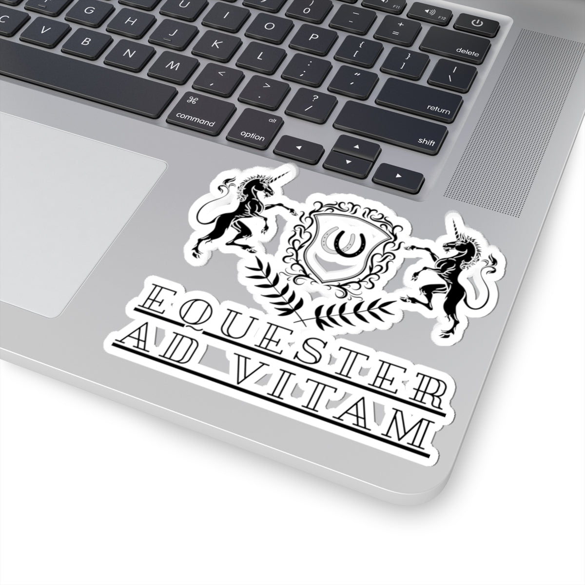 Laptop with a sticker featuring a crest and text 'Equester Ad Vitam' on a white background