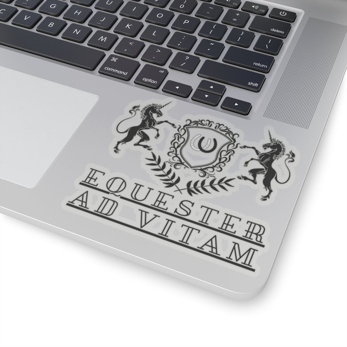 Laptop with a decorative sticker featuring unicorns and text on the palm rest area.