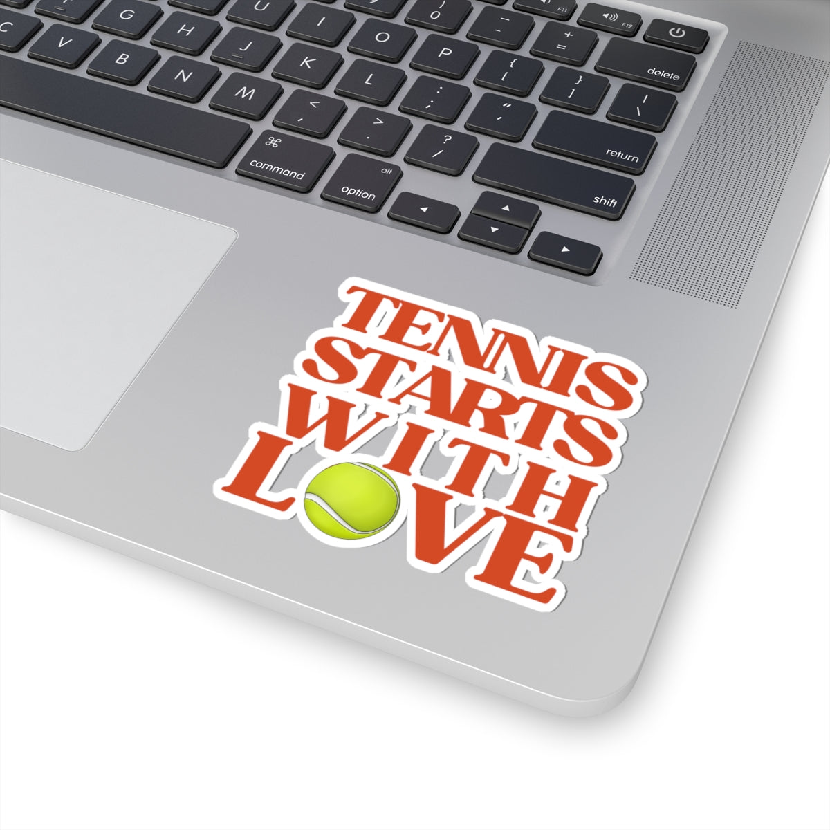 Laptop with a sticker that says 'Tennis Starts with Love' on a white background