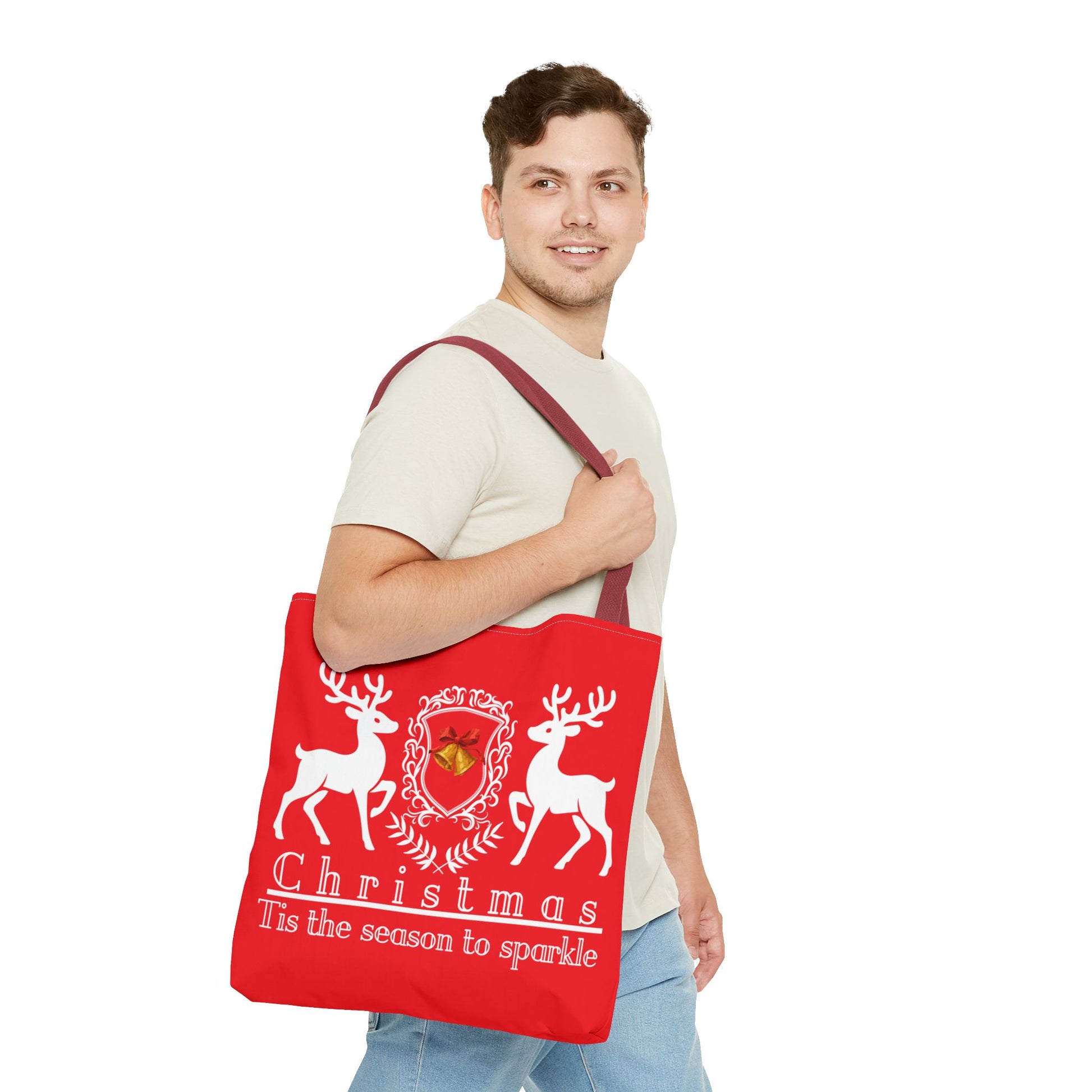 Man holding a red tote bag with Christmas design and text on a white background
