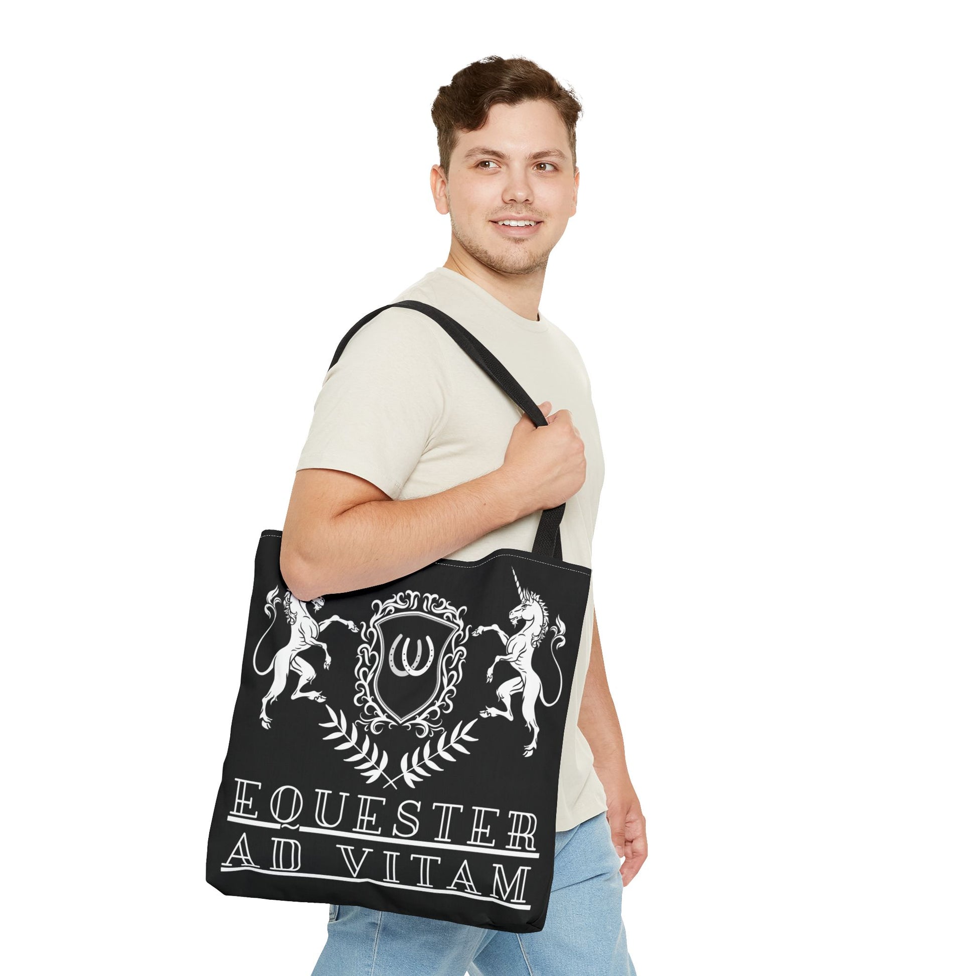 Man holding a black tote bag with white designs and text on a white background