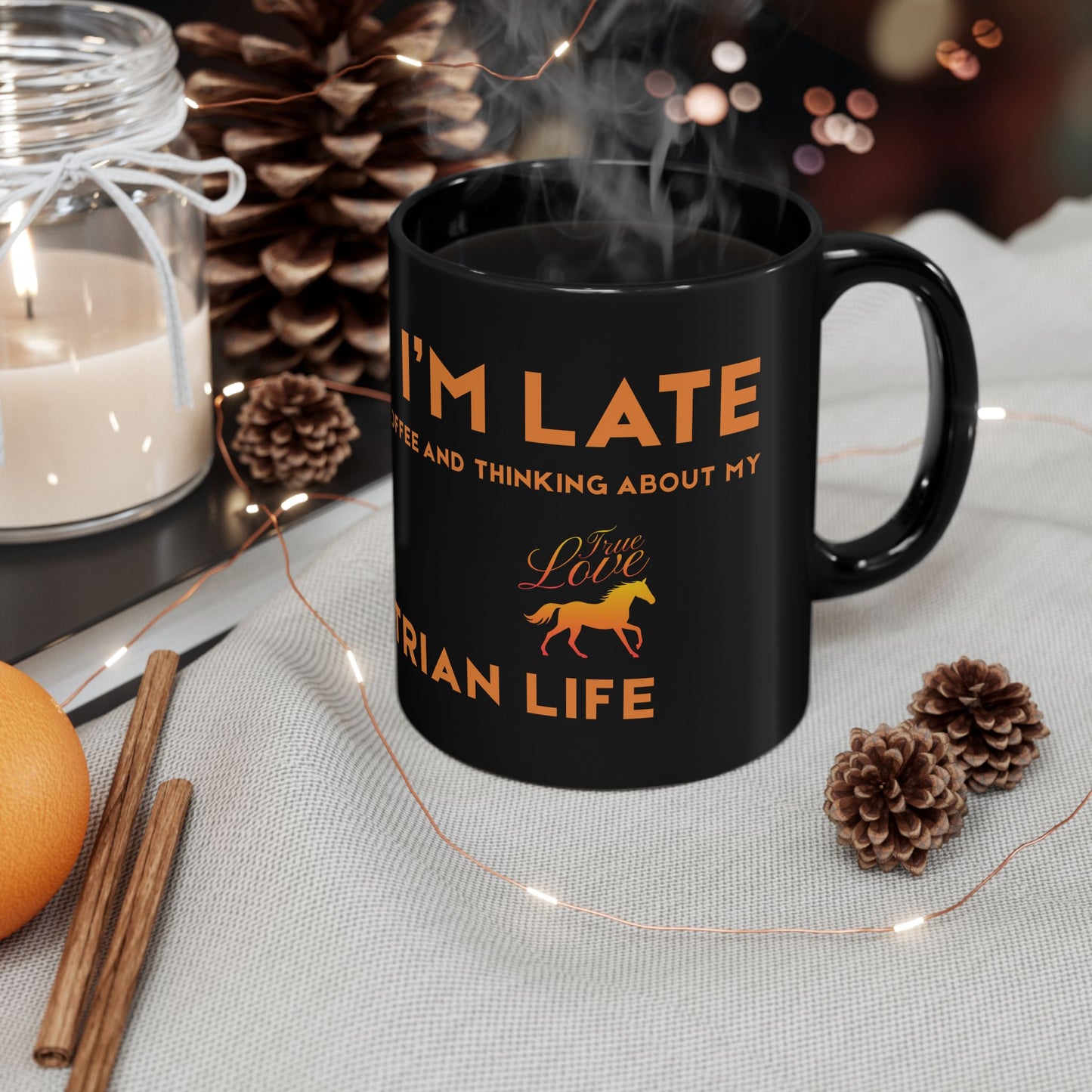 Black mug with orange text and a horse graphic on a table with decorative items.