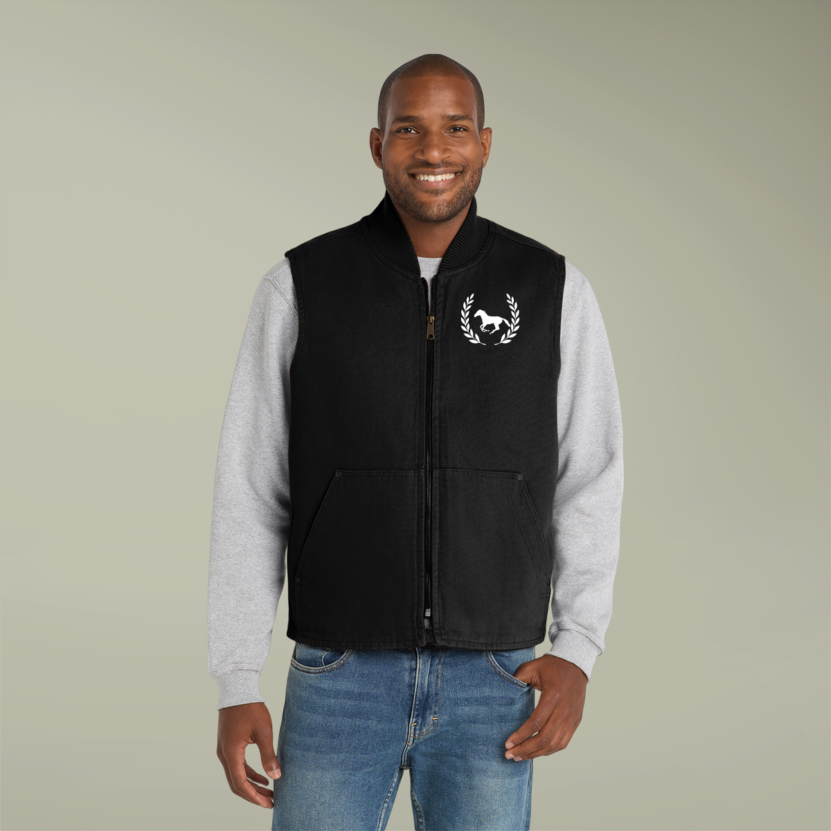 Man wearing a black vest with a logo on a plain background