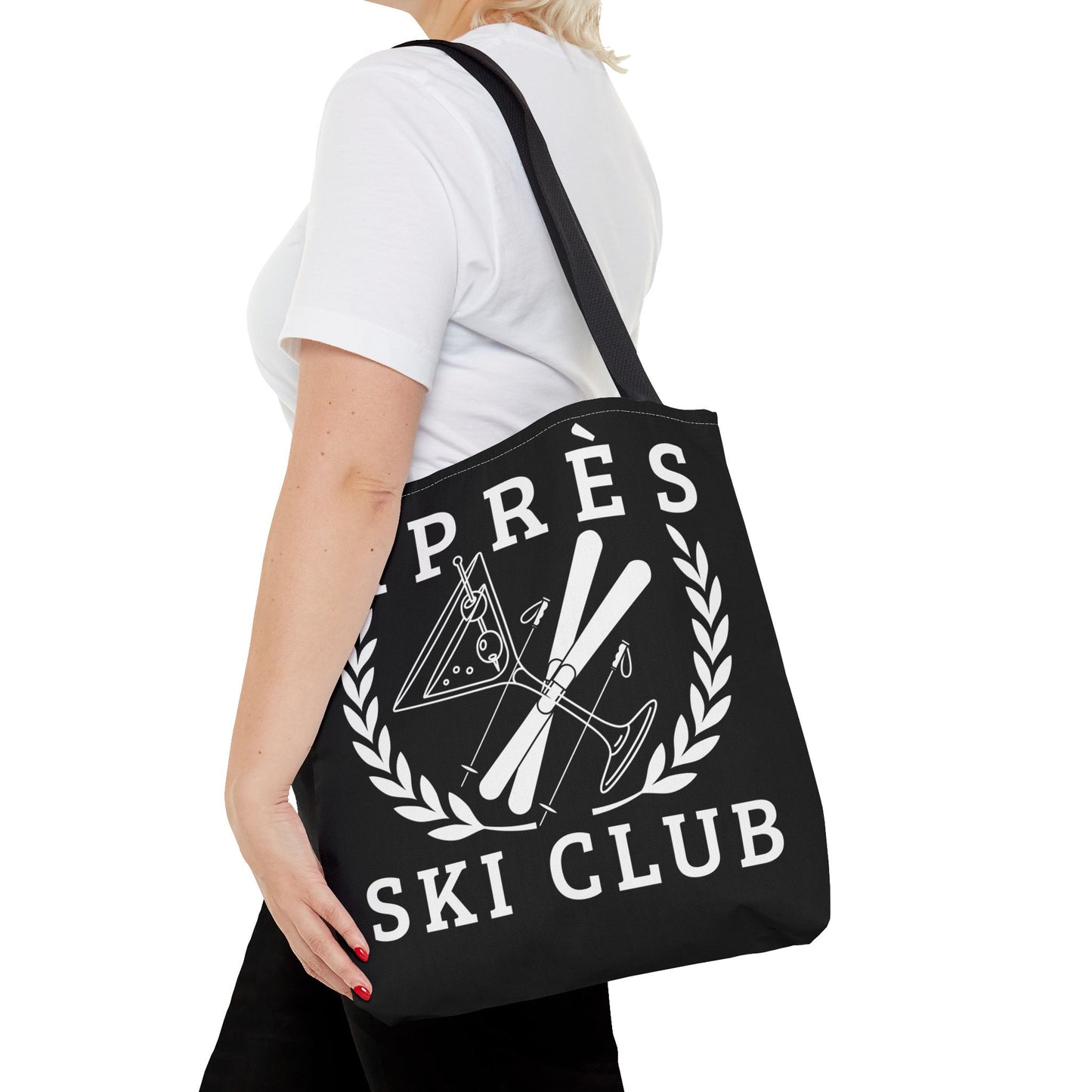 ski tote bag Person holding a black tote bag with 'Après Ski Club' design on a white background