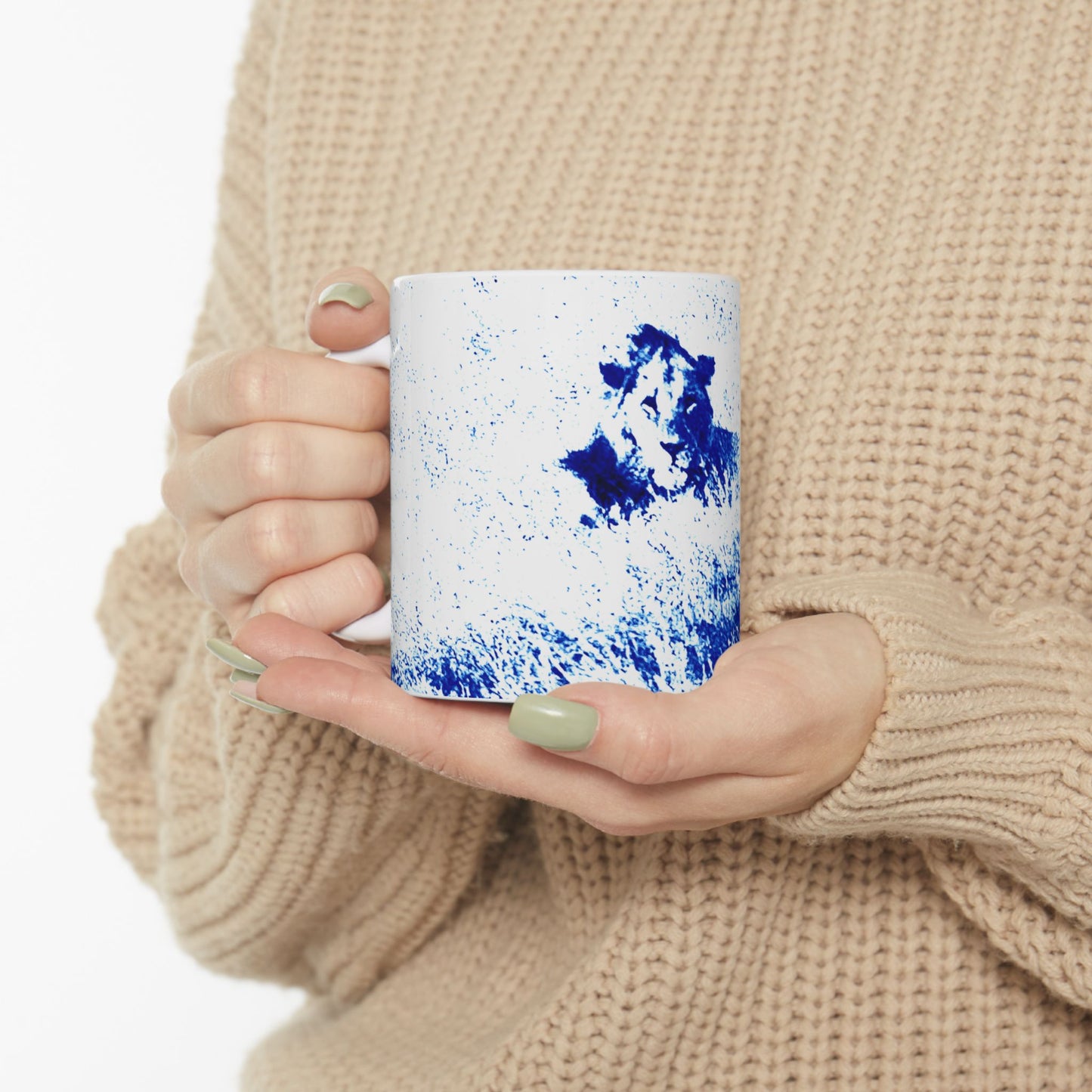 Person holding a mug with blue and white design, wearing a beige sweater.