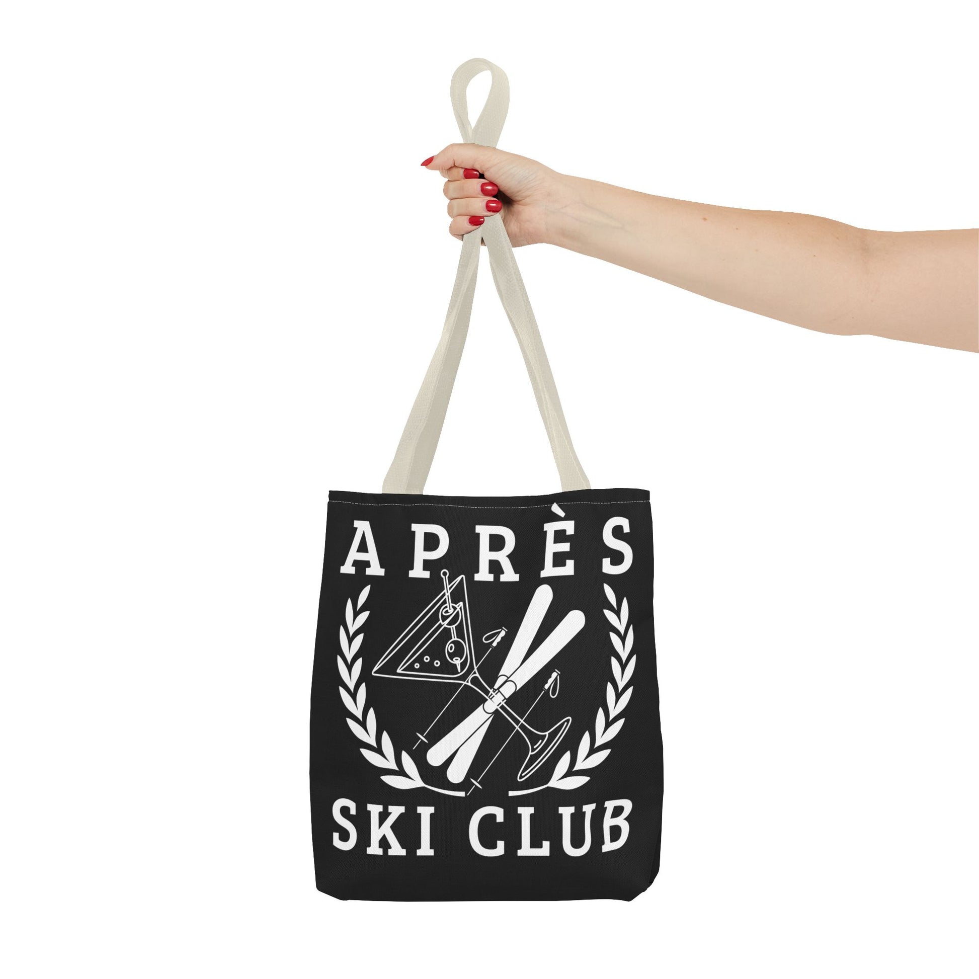 ski tote bag Black tote bag with 'Ap
es Ski Club' text and design held by a hand on a white background