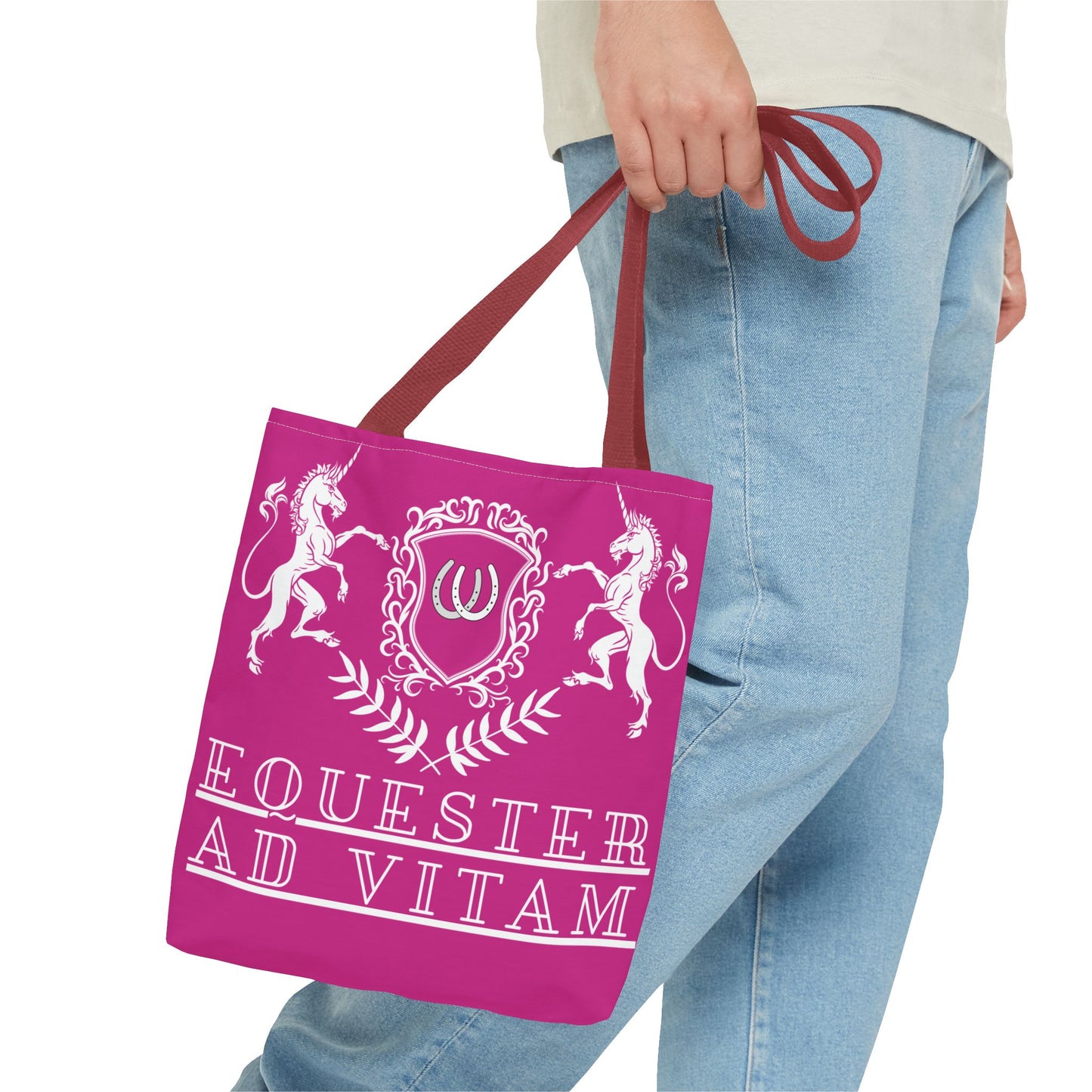 Person holding a pink tote bag with unicorn design and 'Equester Ad Vitam' text.