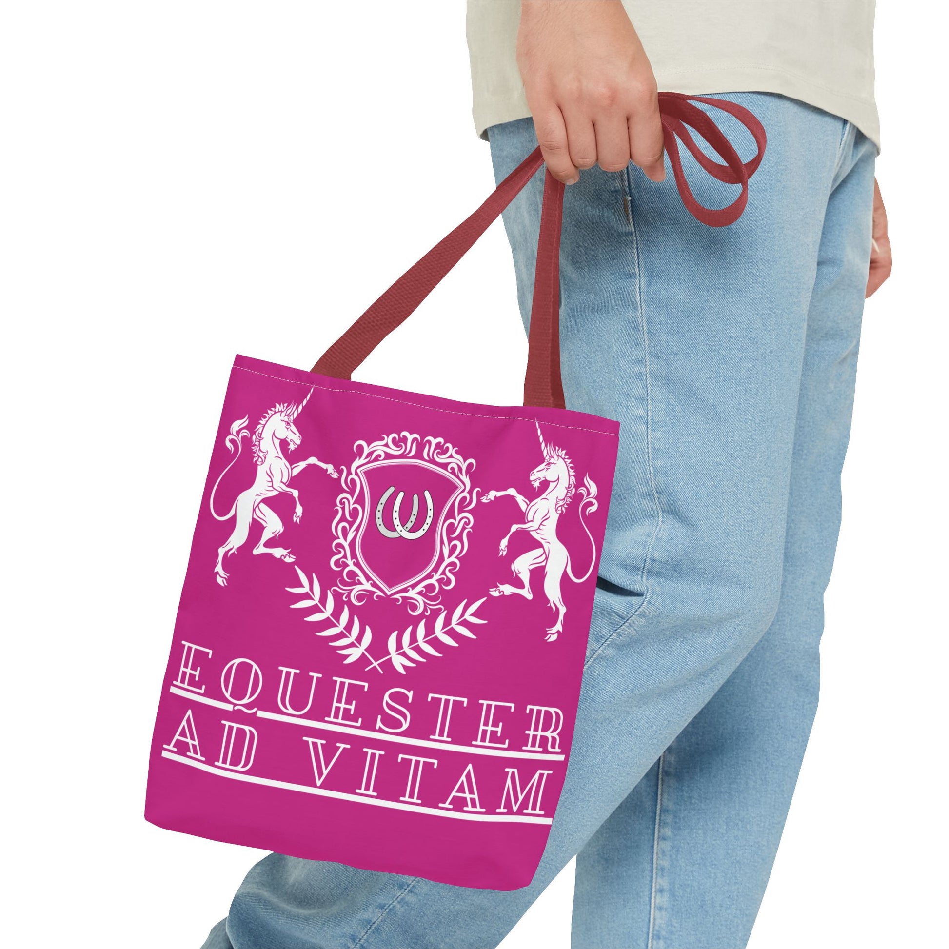 Person holding a pink tote bag with unicorn design and 'Equester Ad Vitam' text.