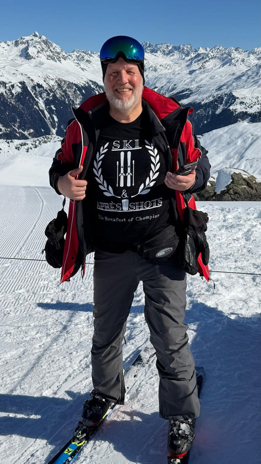 Man in skiing gear with skis and backpack on a snowy mountain