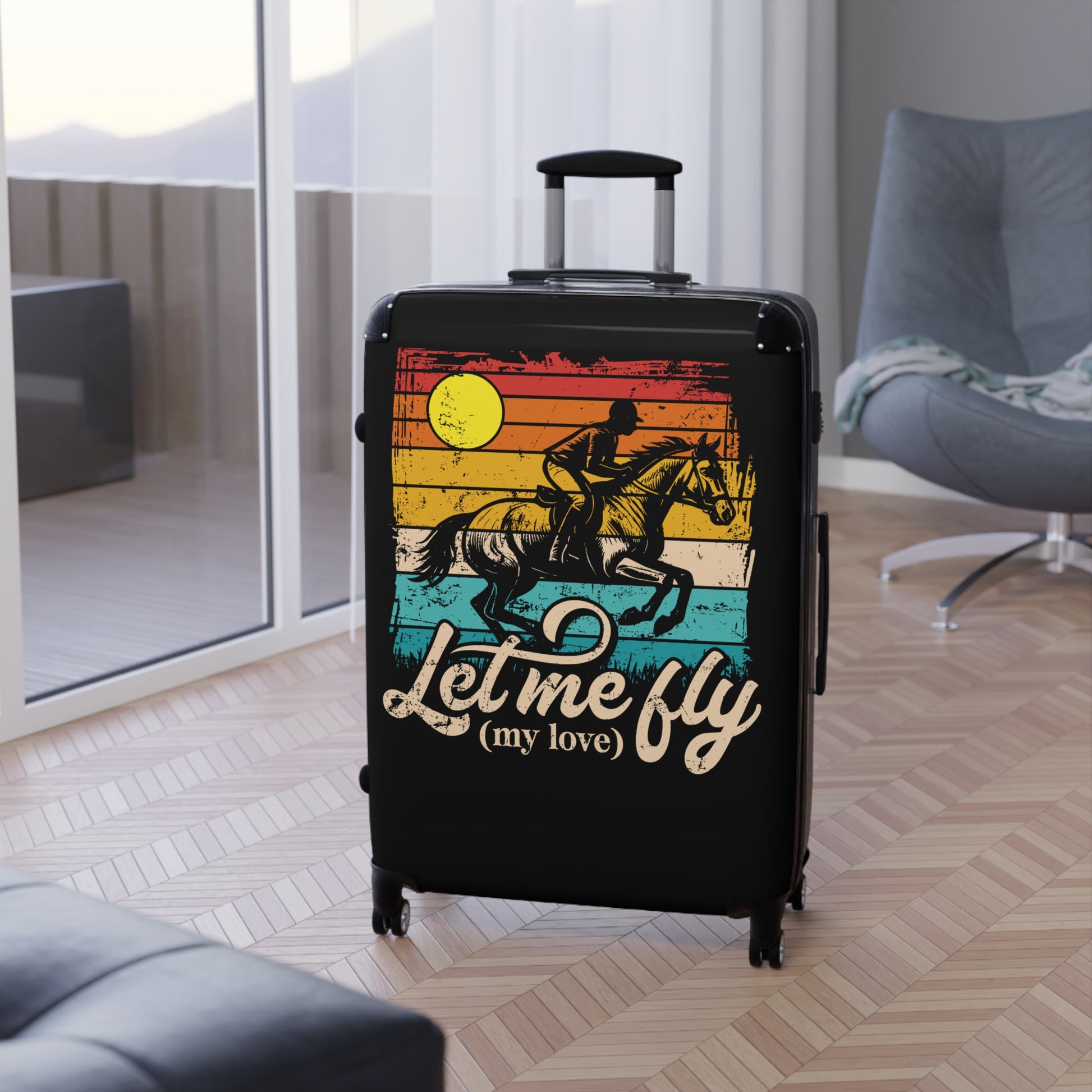 Black suitcase with a colorful design and text 'Let me fly (my love)' in a room with a couch and chair.