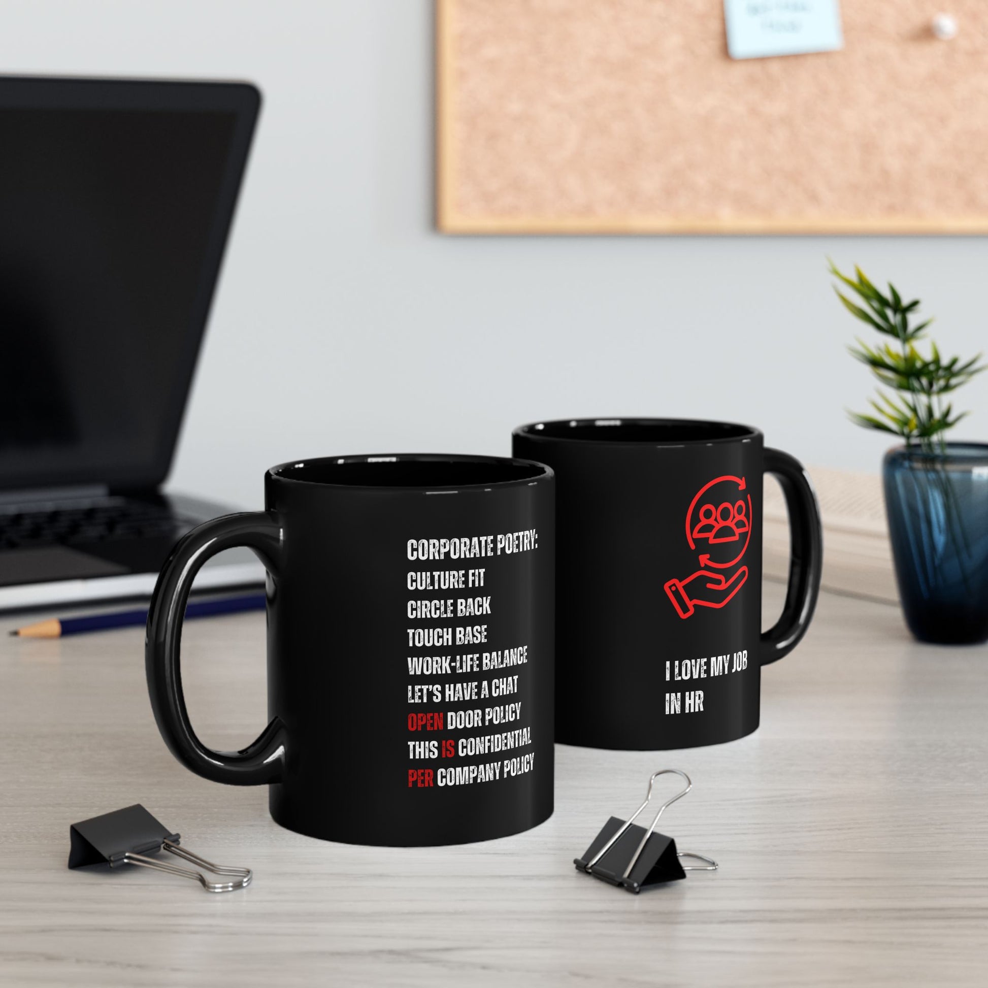 HR Coffee Mug Two black mugs with humorous text designs on a desk with office supplies.