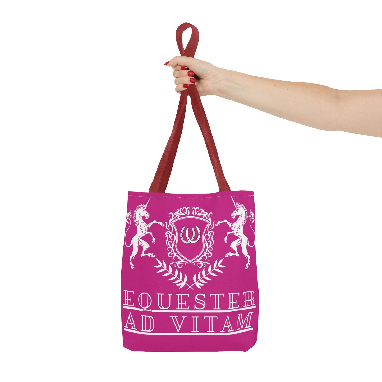 Pink tote bag with horse design and text held by a hand on a white background