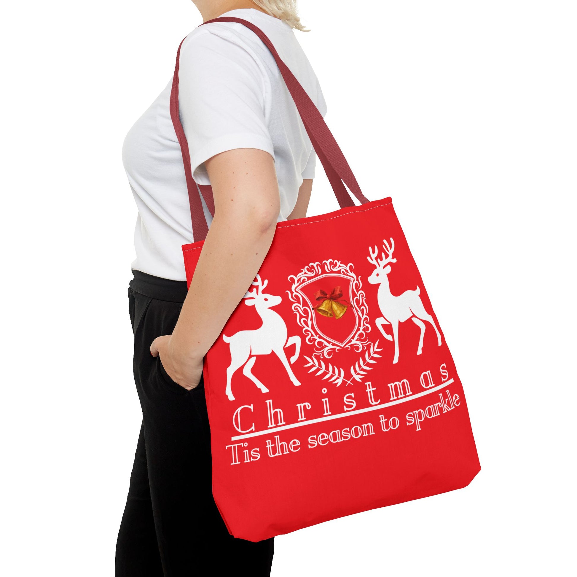 Red tote bag with Christmas design held by a person on a white background