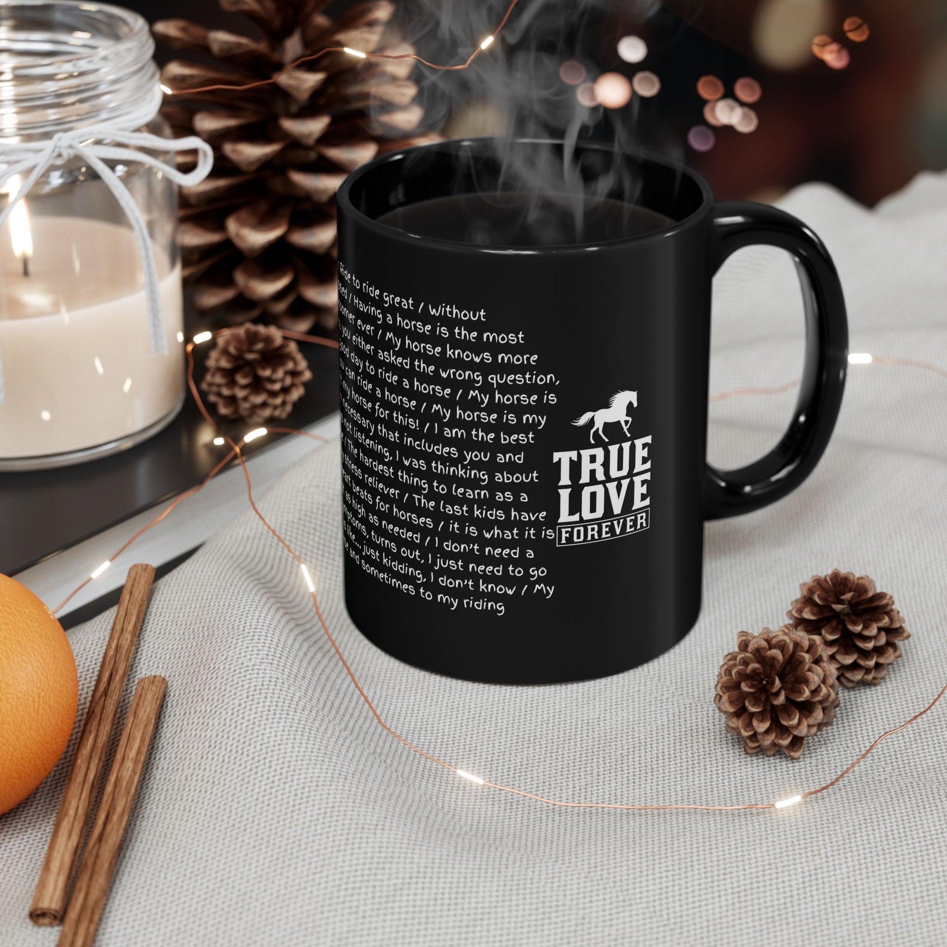 Black mug with text and a horse graphic on a table with decorative items