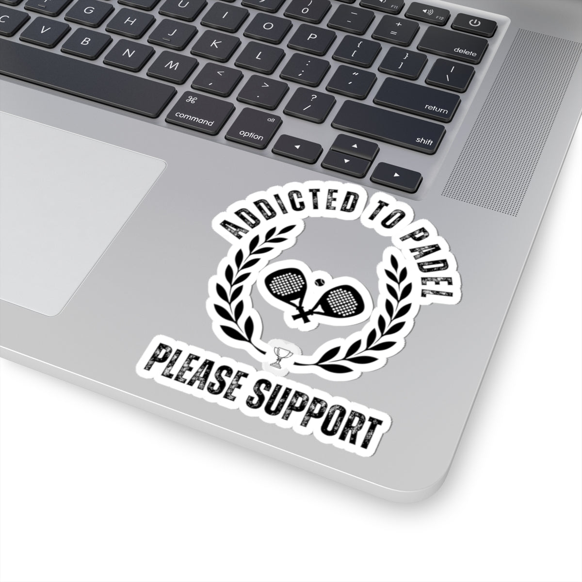 Laptop with a sticker that reads 'Addicted to Padel Please Support' on the palm rest area.