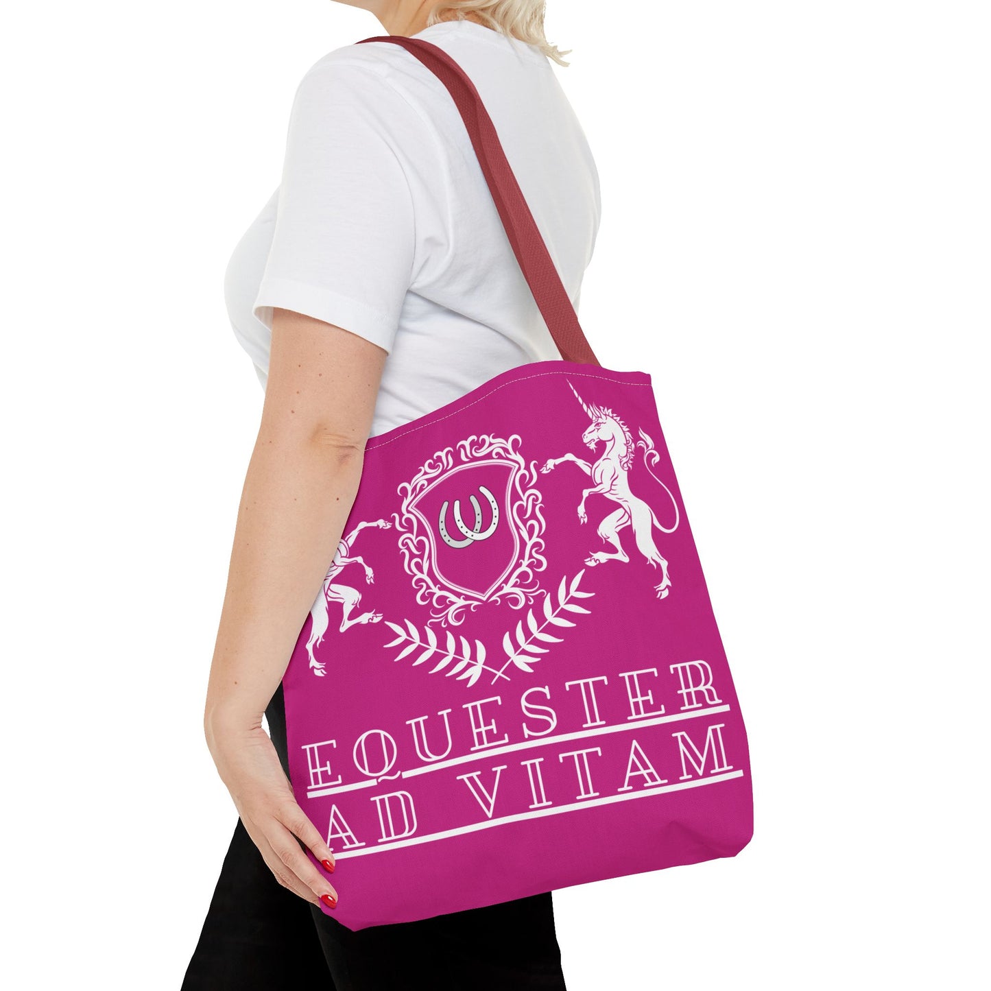 Person holding a pink tote bag with white text and designs on a white background