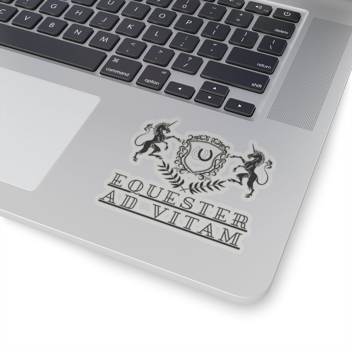 Laptop with a decorative sticker featuring unicorns and text on the palm rest area.