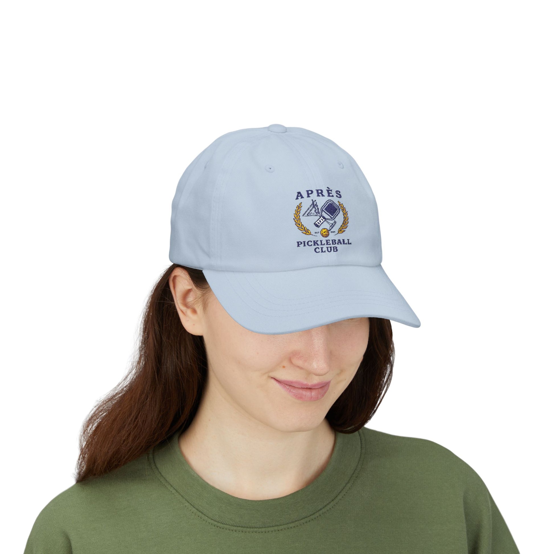 Person wearing a light blue cap with an embroidered design on a white background