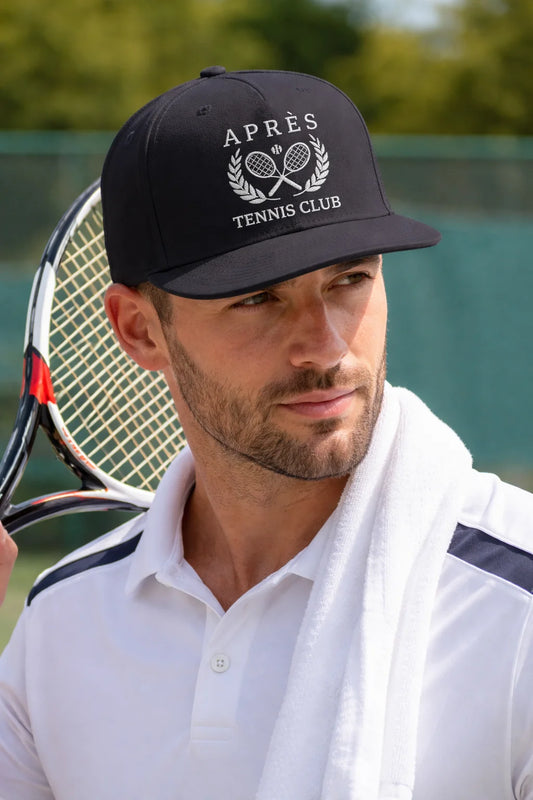 Tennis Cap for Men Man holding a tennis racket with an 'Apres Tennis Club' cap on a tennis court