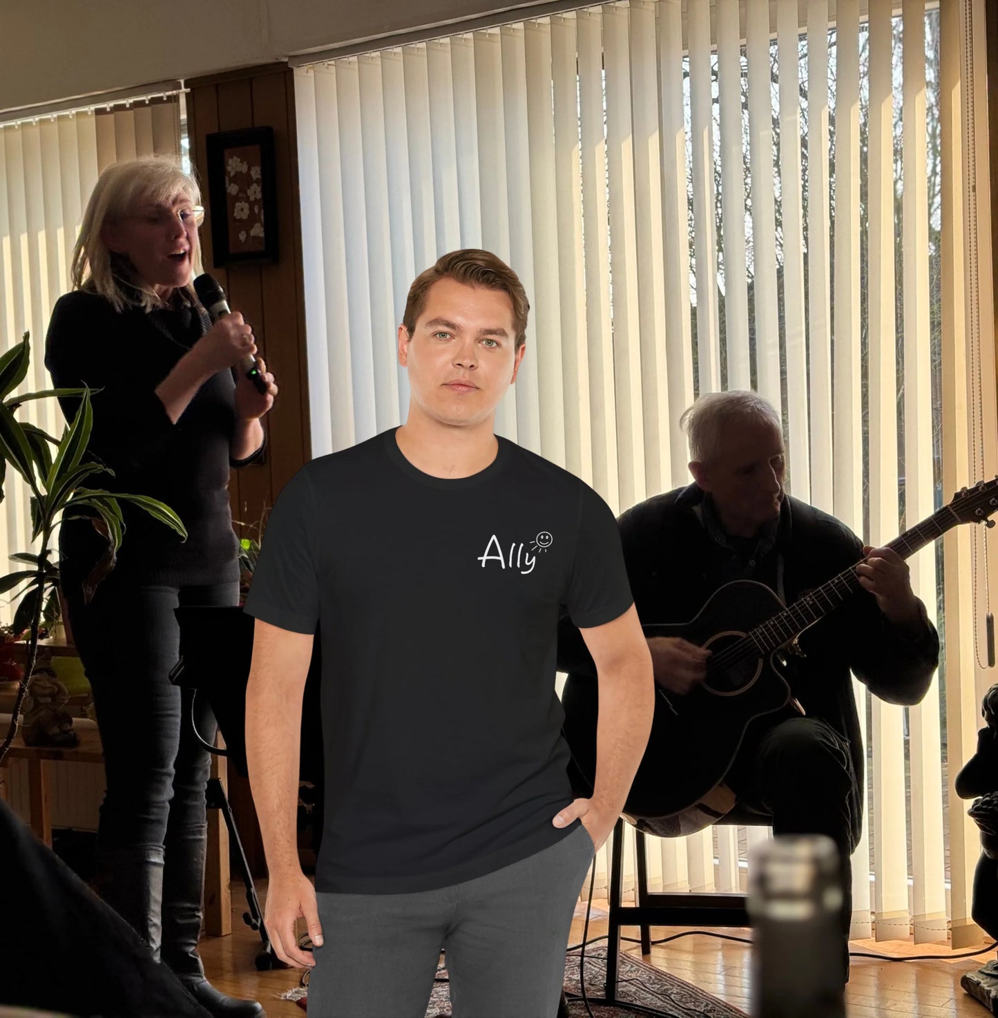 Ally music band Shirt Man wearing a black t-shirt with 'Ally' logo in a room with people playing music.