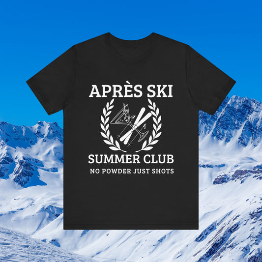 Apres Ski Shirt A black short-sleeve graphic T-shirt displayed against a snowy mountain and blue sky background. The shirt has a white printed design reading 'APRÈS SKI SUMMER CLUB' with 'NO POWDER JUST SHOTS' below, plus ski and snowboard graphics inside a laurel wreath.
