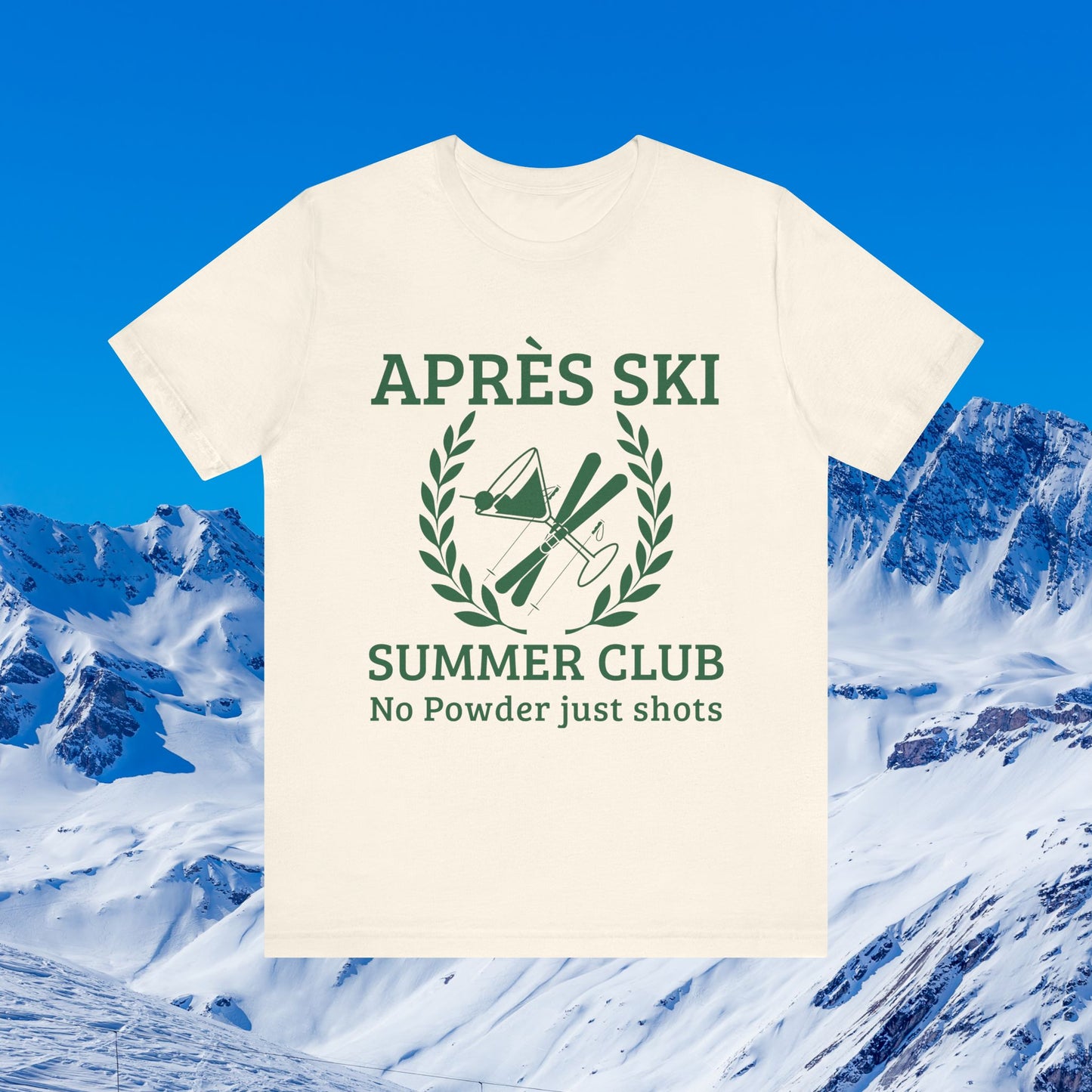 Apres ski clothes ladies An off-white short-sleeve t-shirt with a dark green graphic print reading 'APRÈS SKI SUMMER CLUB No Powder just shots' with ski equipment inside a laurel wreath, shown against a snowy mountain and blue sky background.
