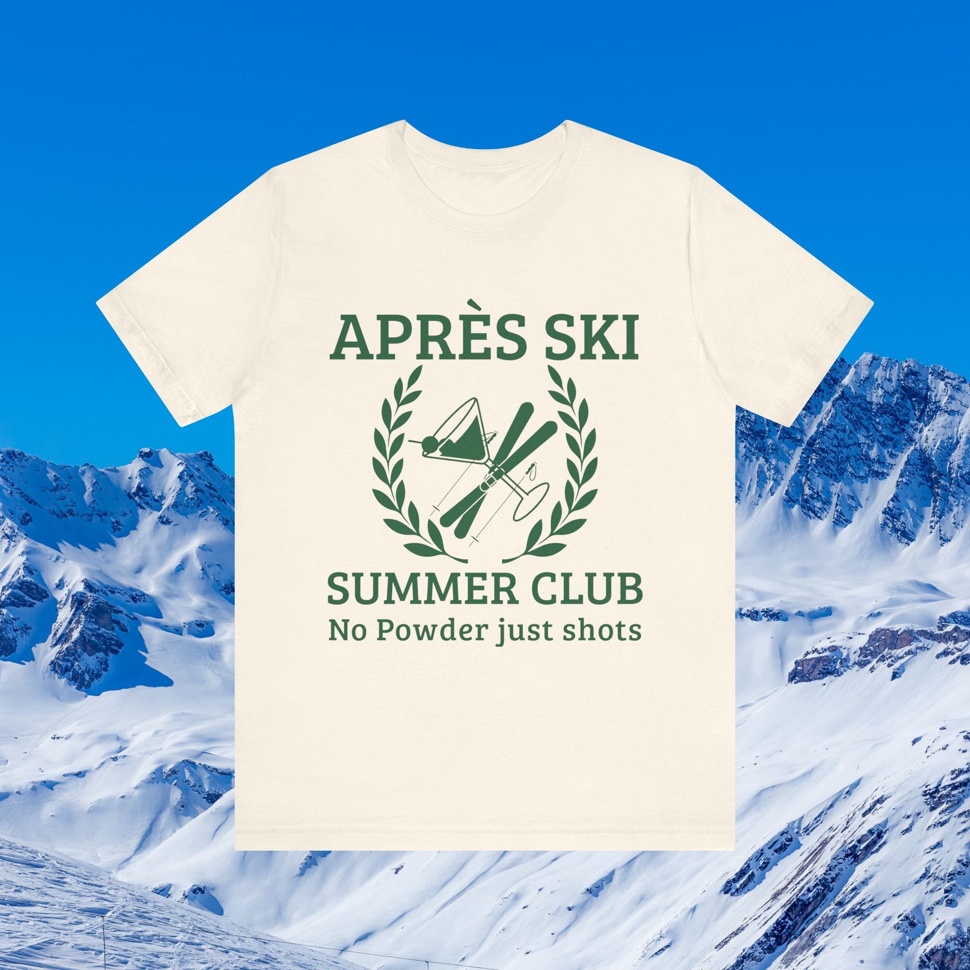 Apres ski clothes ladies An off-white short-sleeve t-shirt with a dark green graphic print reading 'APRÈS SKI SUMMER CLUB No Powder just shots' with ski equipment inside a laurel wreath, shown against a snowy mountain and blue sky background.