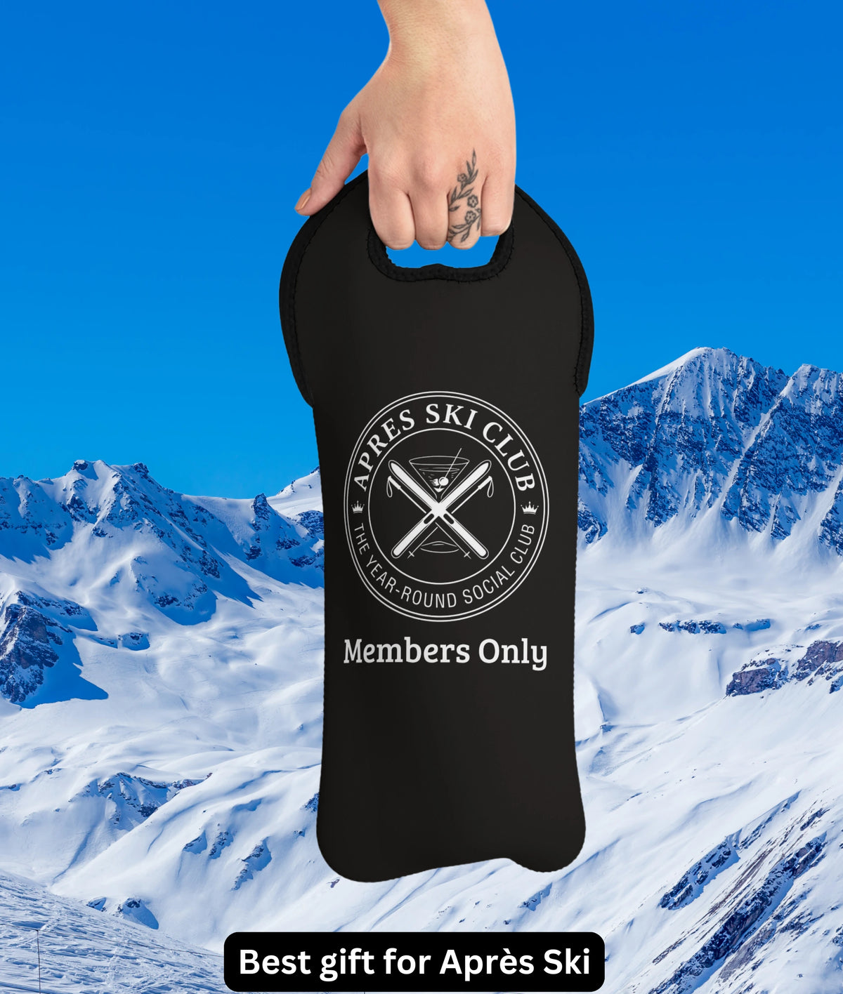 Apres ski gifts A black insulated bottle carrier bag held by a hand against a snowy mountain and blue sky background. The bag features a white circular logo that reads 'Après Ski Club' and 'Members Only'.