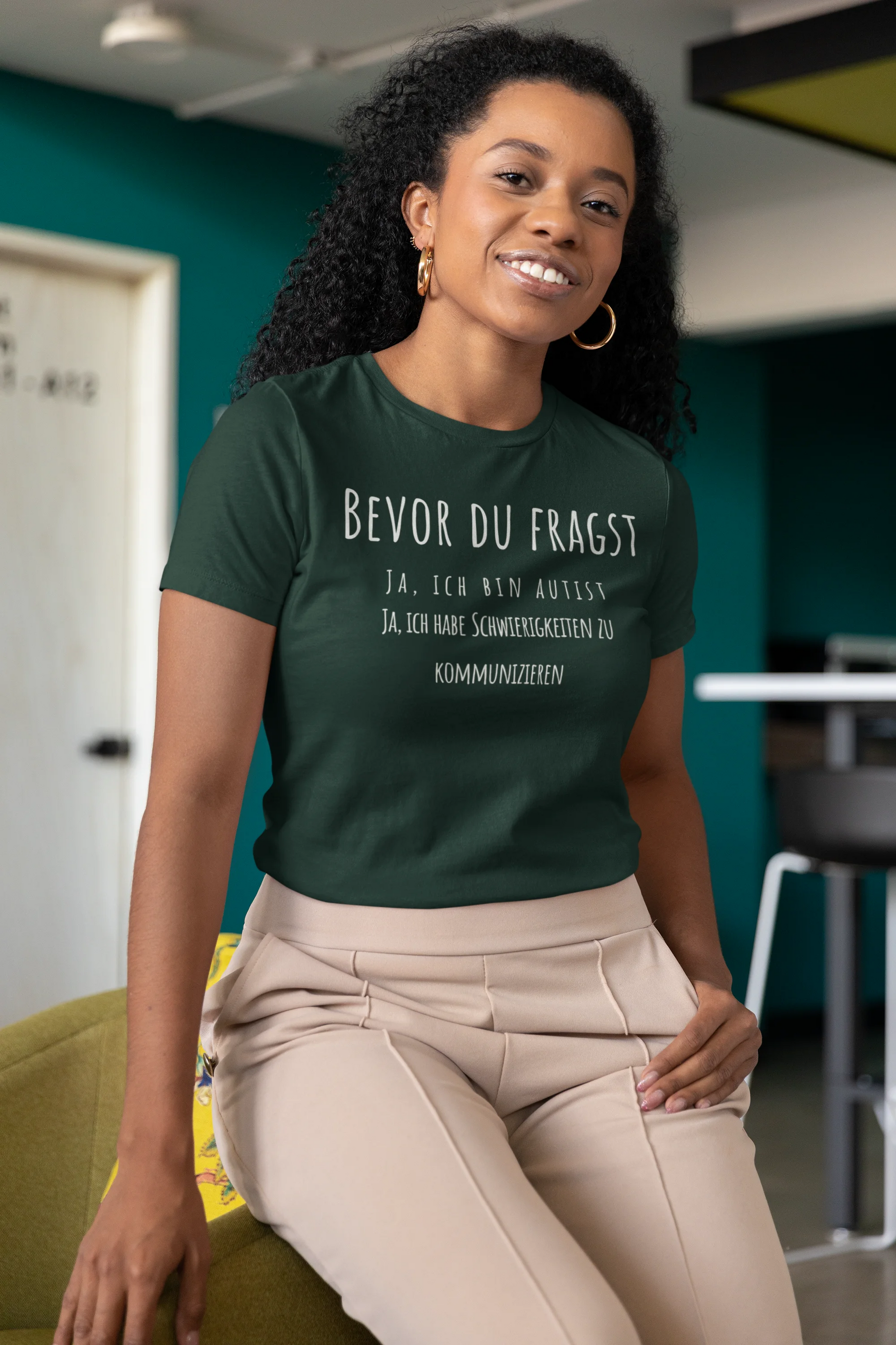 Person wearing a green t-shirt with text in a modern indoor setting