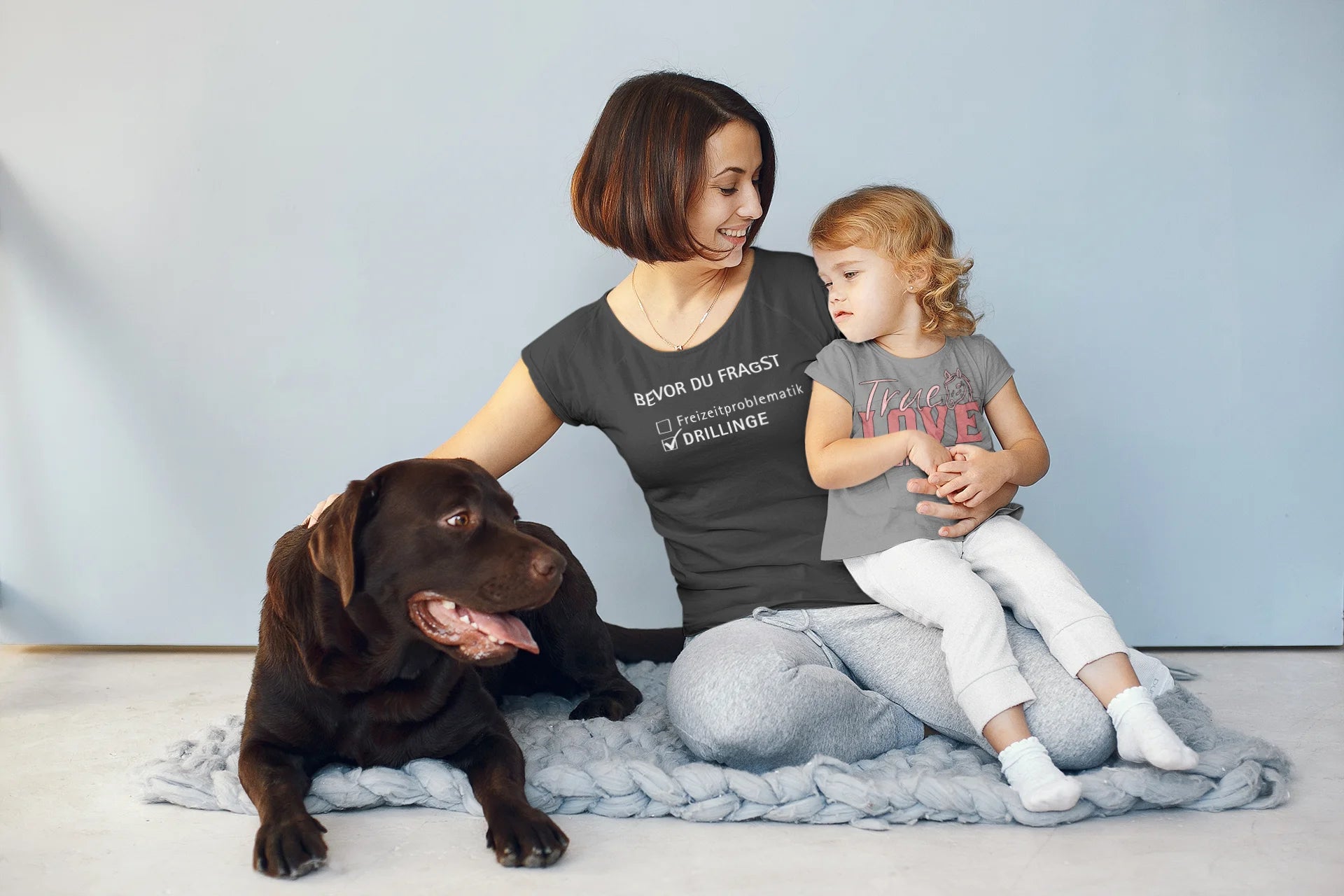 Gift for Triplets Woman and child sitting on a blanket with a dog, wearing matching t-shirts.