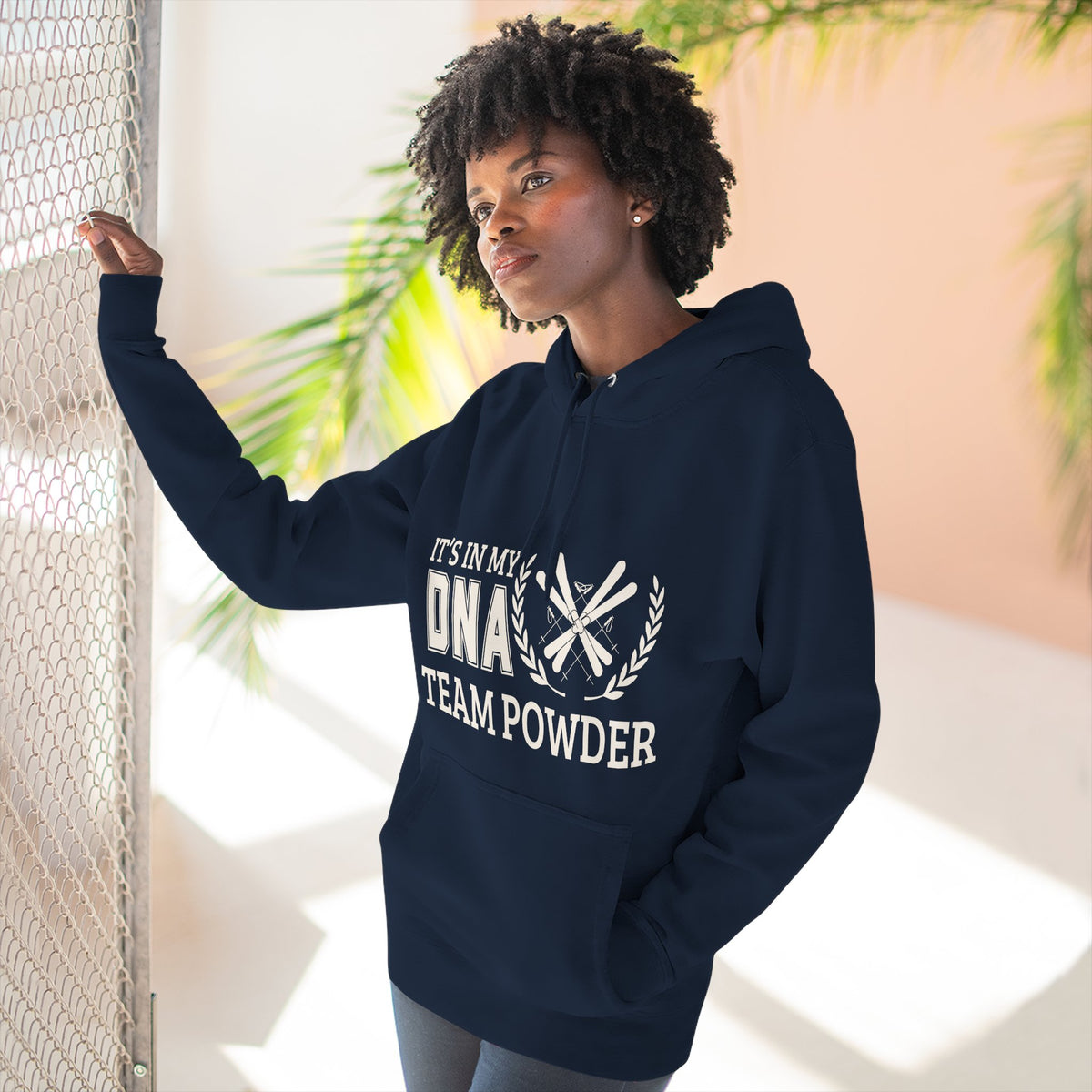 Its in my DNA Person wearing a navy blue hoodie with a graphic design, standing against a light background.