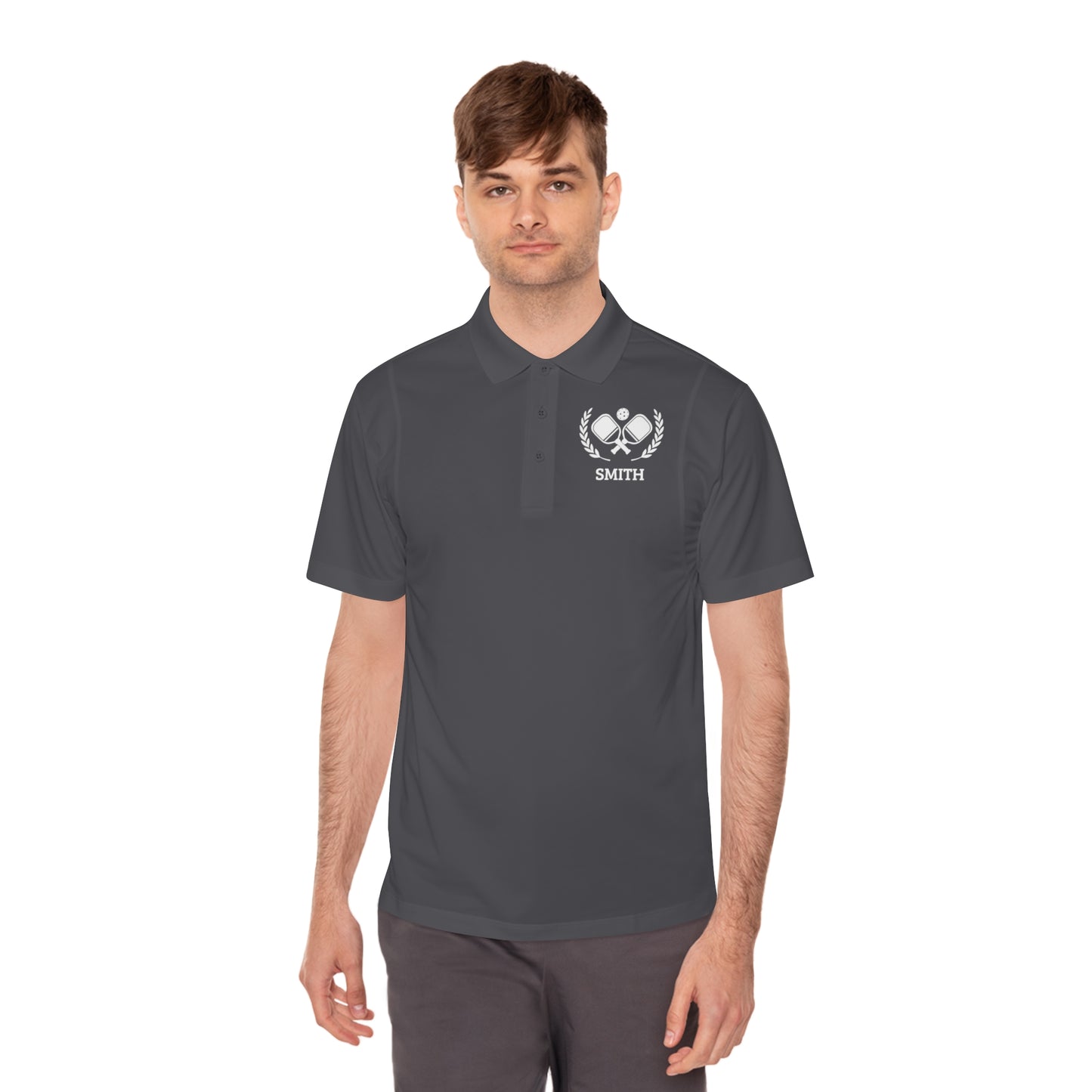 Pickleball Polos Man wearing a dark gray polo shirt with a logo on a white background