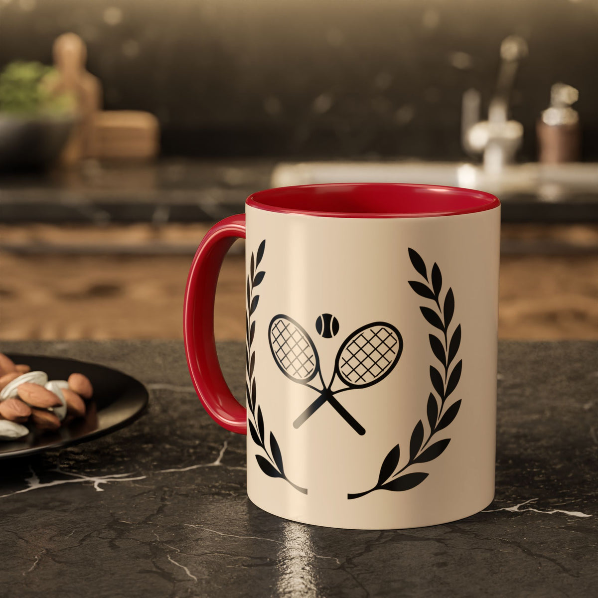 Tennis Coffee Mug A ceramic mug with a cream-colored exterior, a bright red interior and handle, and a black graphic of crossed tennis rackets with a tennis ball and laurel wreaths, set on a dark kitchen countertop.