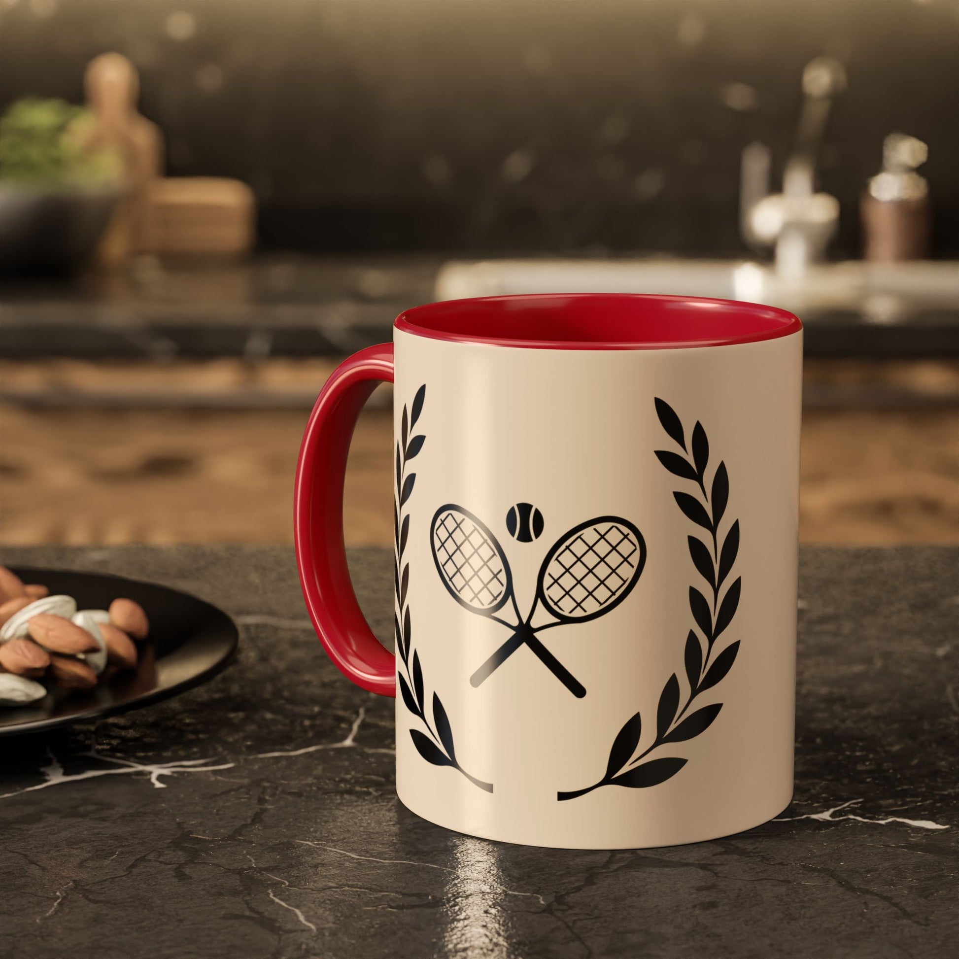 Tennis Coffee Mug A ceramic mug with a cream-colored exterior, a bright red interior and handle, and a black graphic of crossed tennis rackets with a tennis ball and laurel wreaths, set on a dark kitchen countertop.