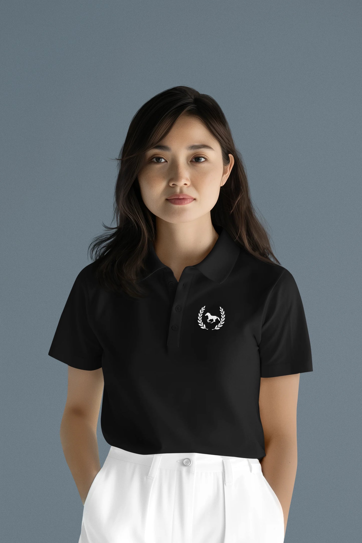 Woman wearing a black polo shirt with a logo on a gray background