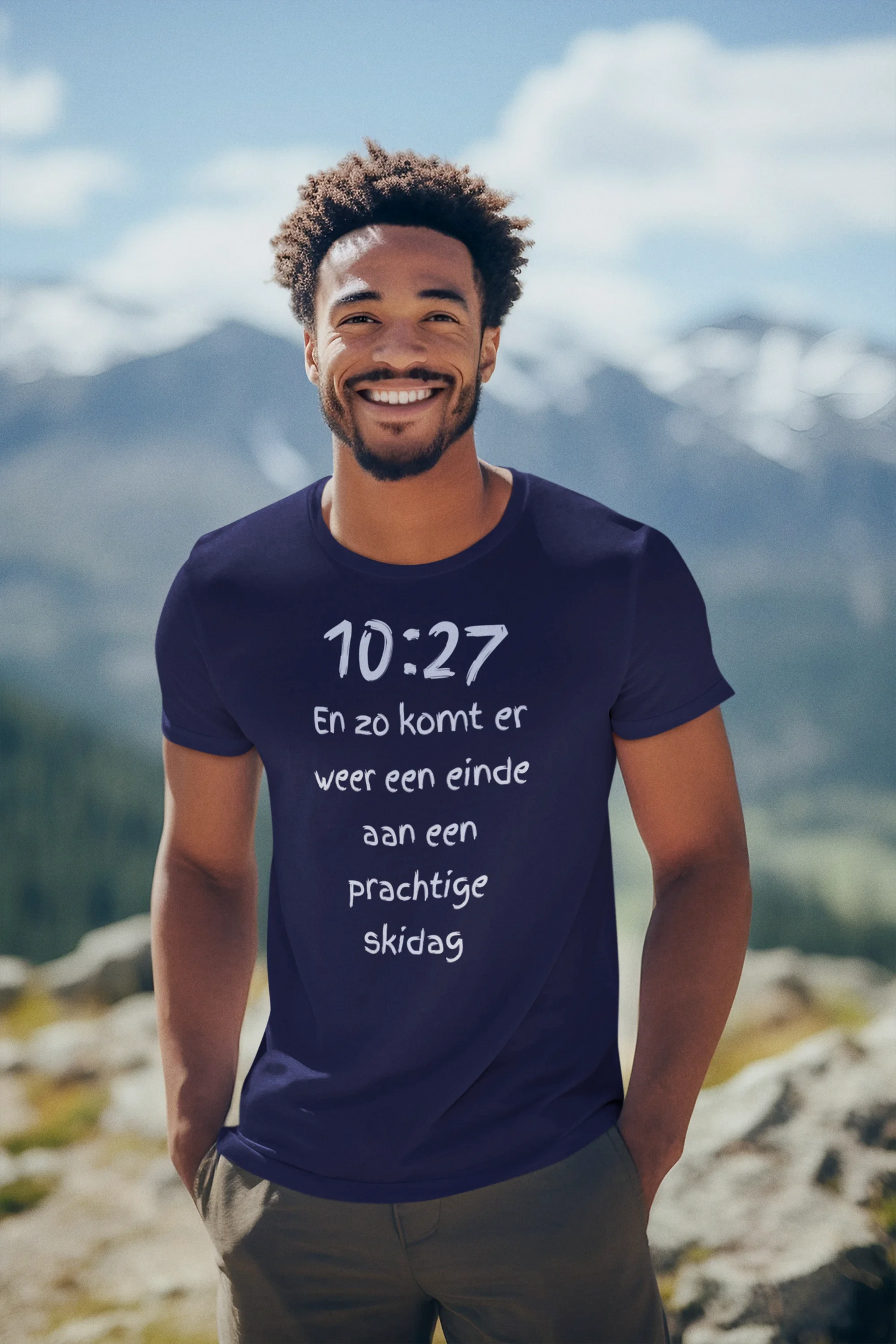Man wearing a blue t-shirt with text standing on a mountain