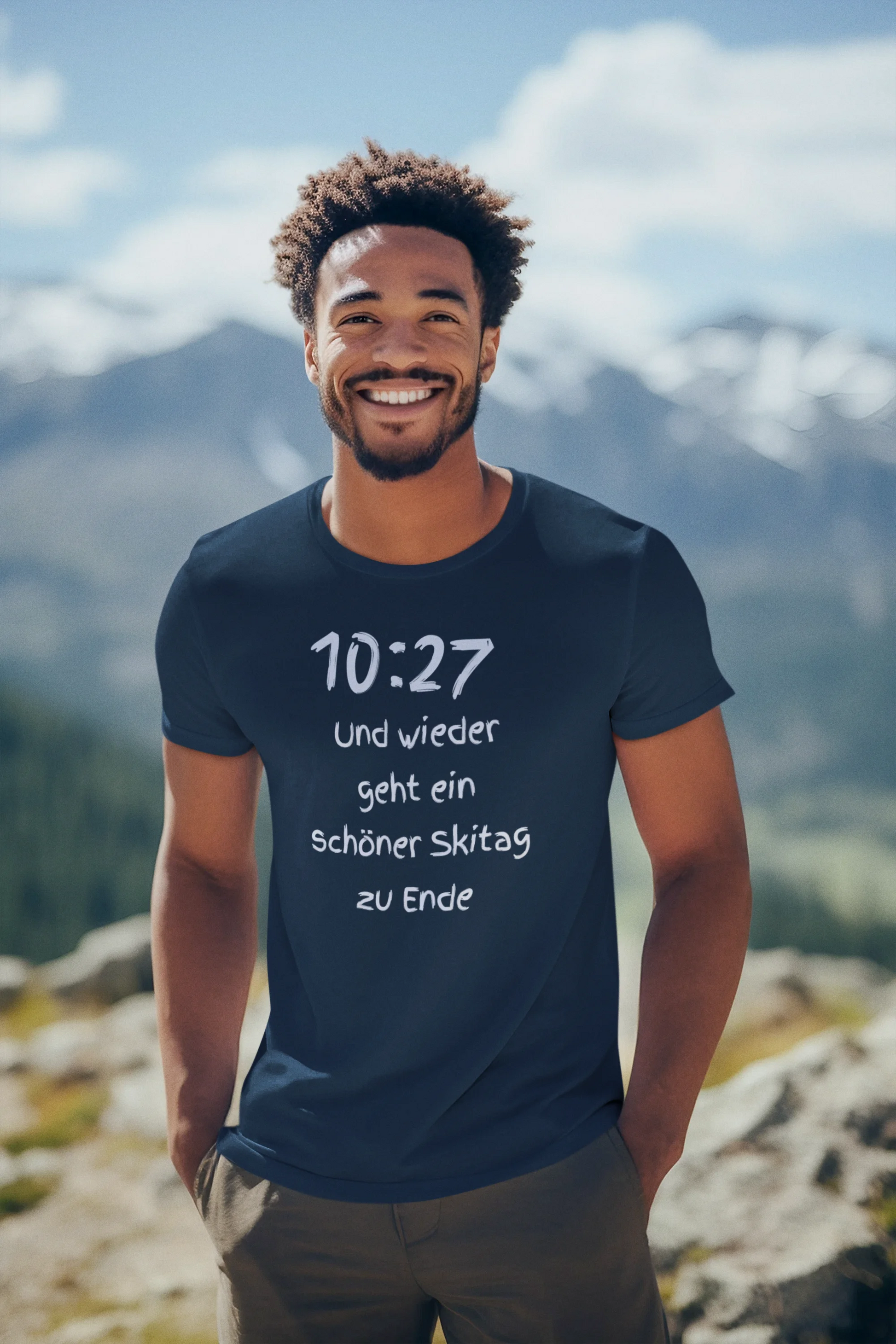 Man wearing a t-shirt with text in front of a mountainous landscape