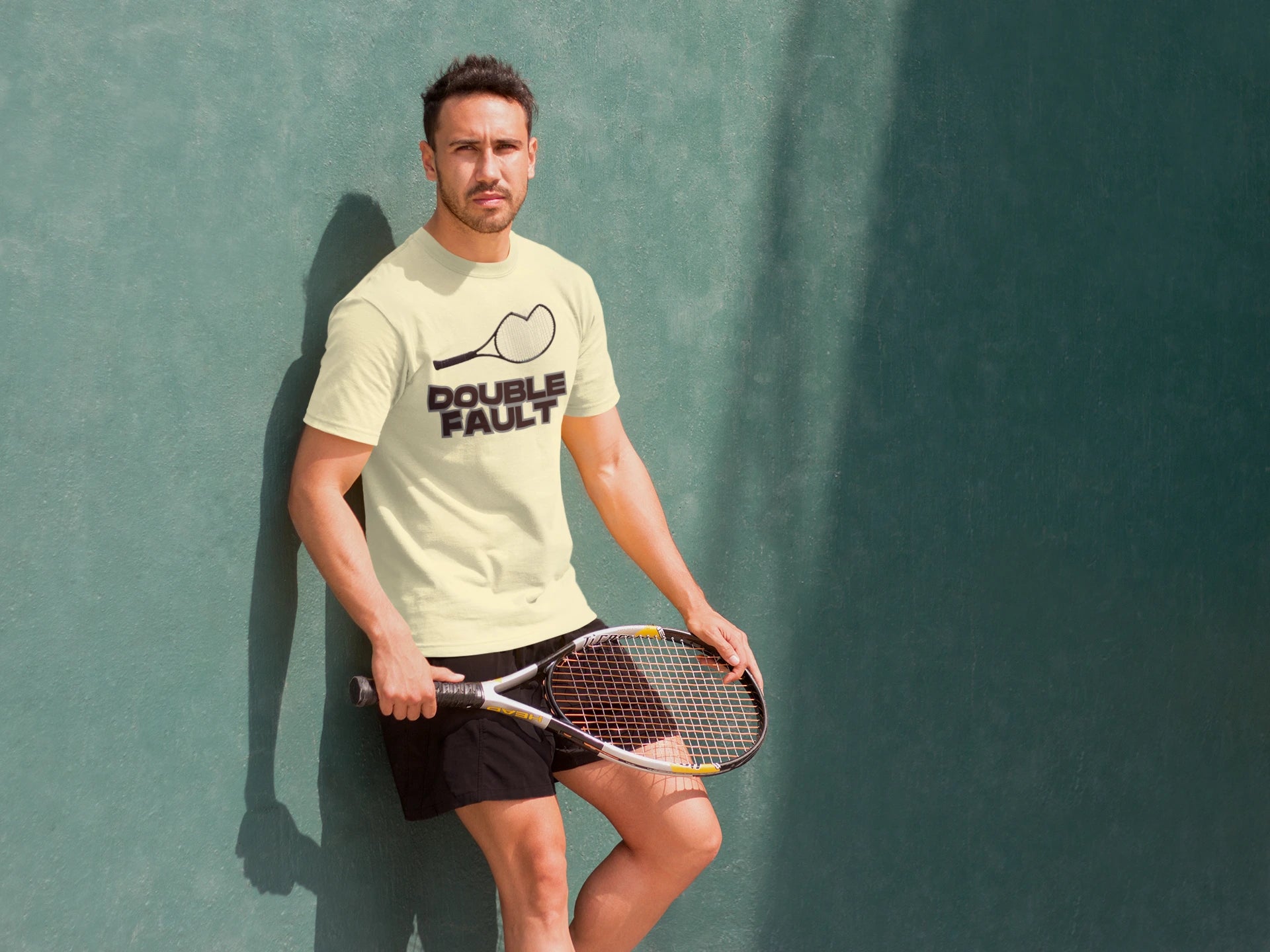 Double Fault Tee Man holding a tennis racket against a textured green wall