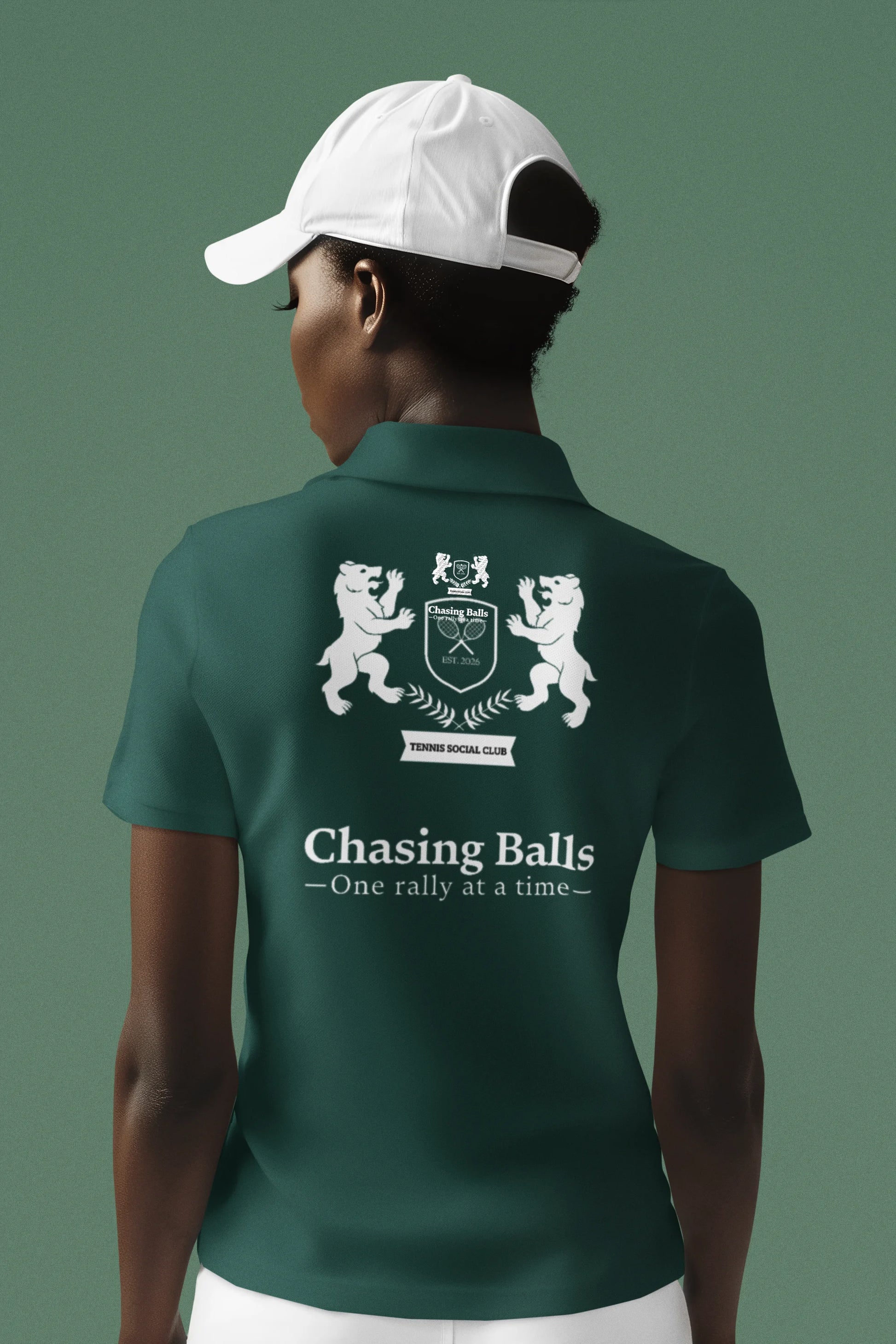 Person wearing a green polo shirt with a logo and text on the back, against a solid background