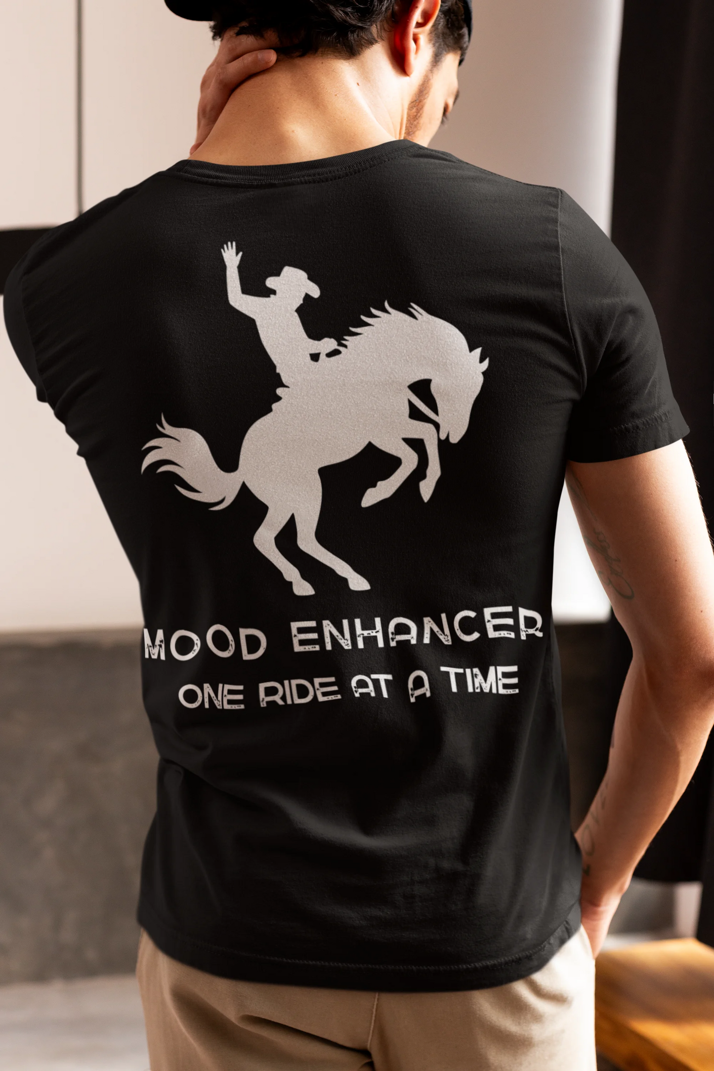 Person wearing a black t-shirt with a white graphic and text on the back.