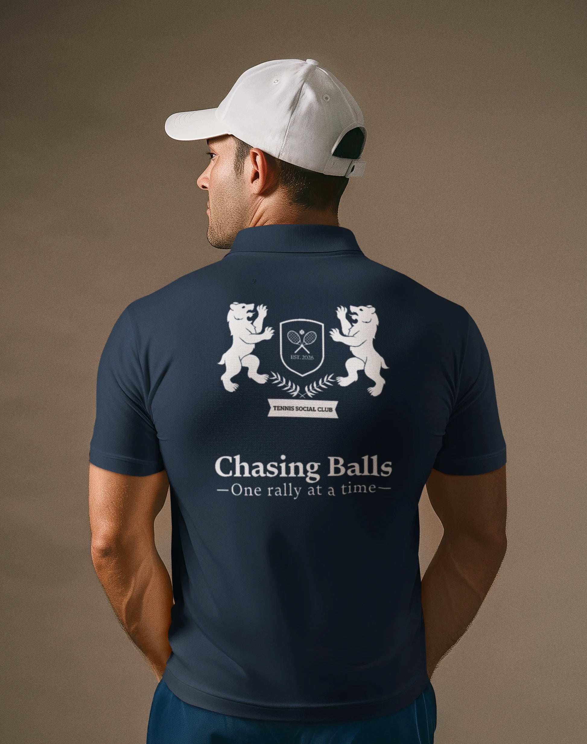 Man wearing a navy blue polo shirt with a logo and text on the back, on a brown background